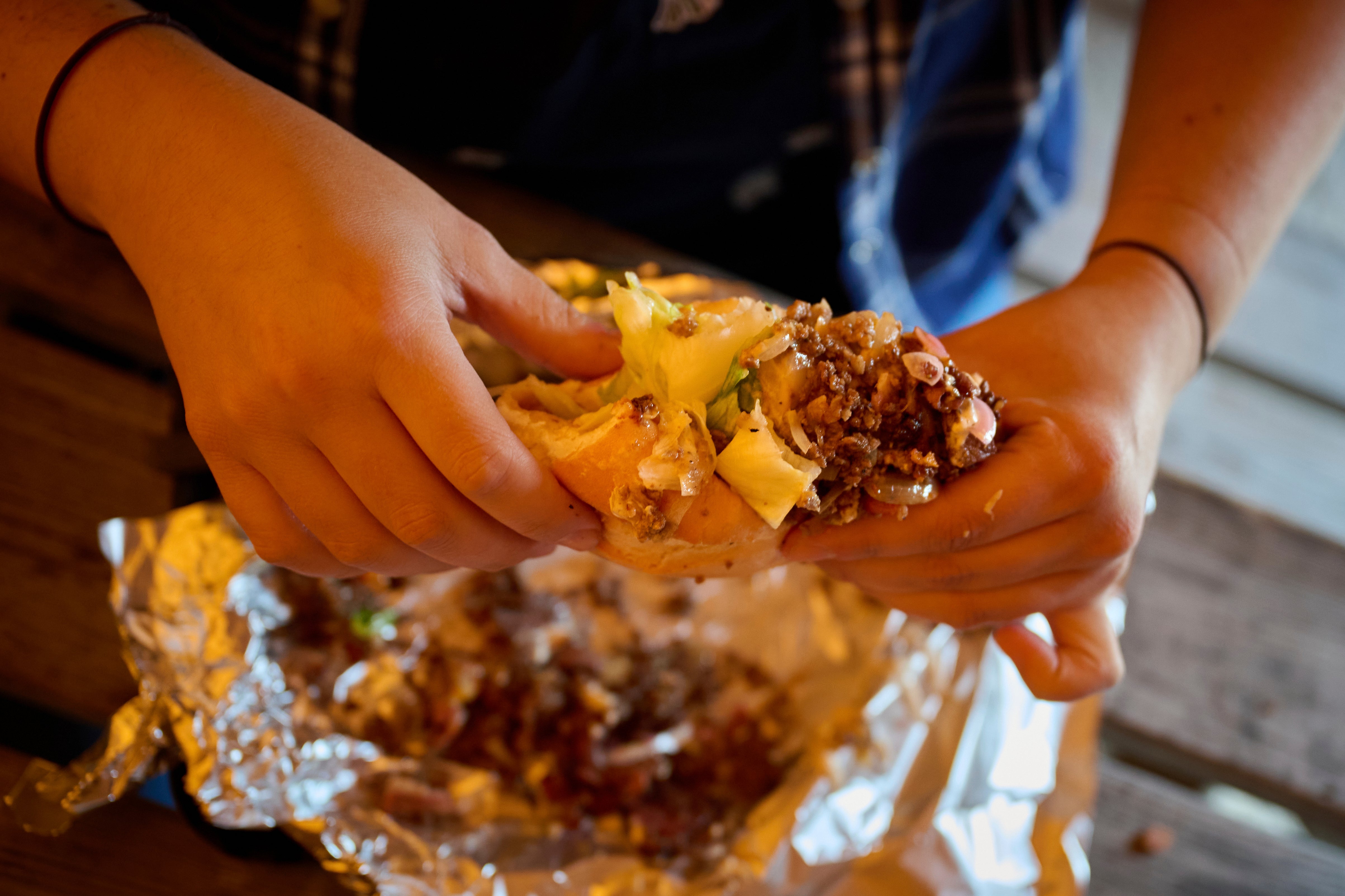 A person holds a sandwich at the Stejk Street Food food place in Kiruna, Sweden, Sunday, Aug. 17, 2025. (AP Photo/Malin Haarala)