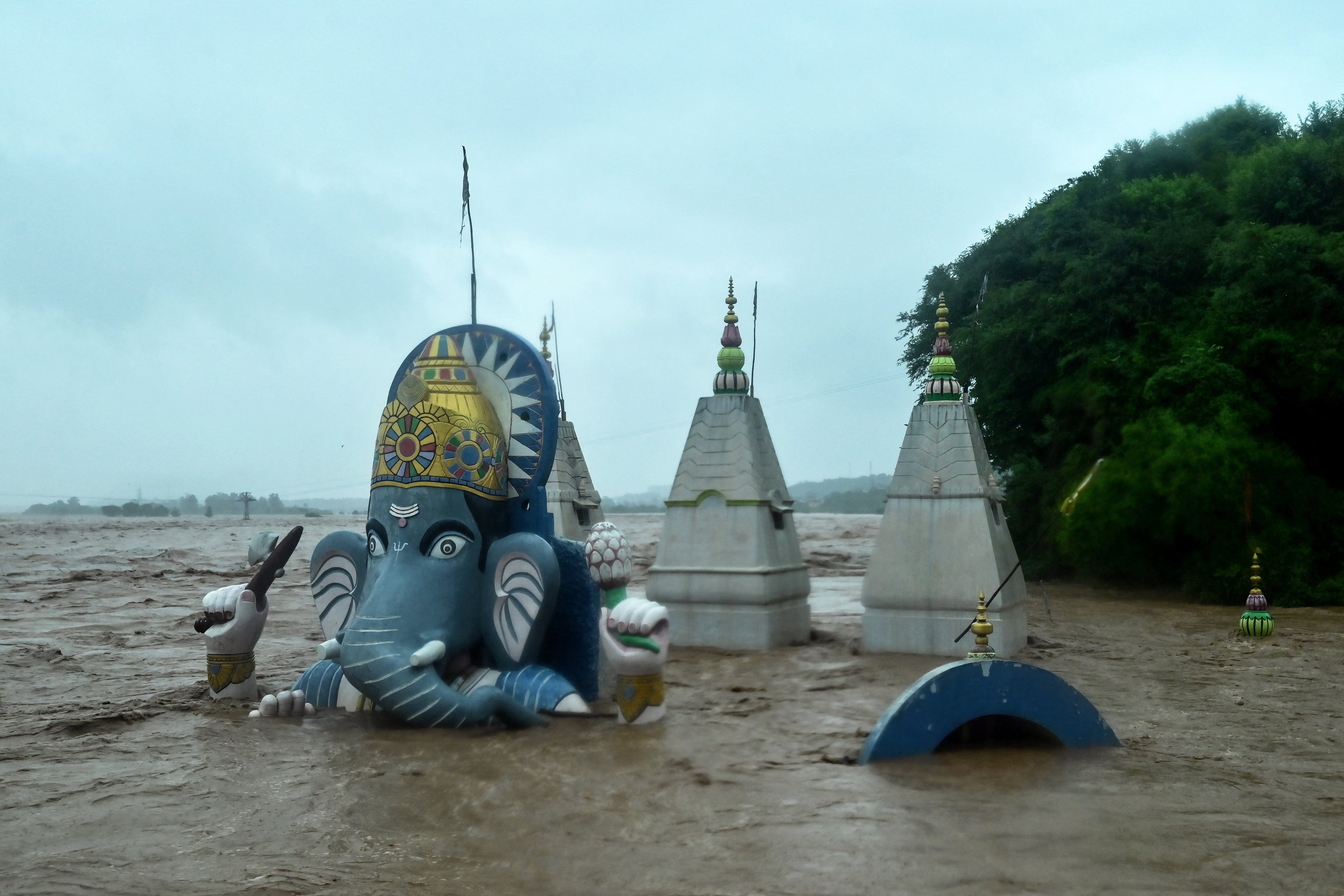 A Hindu temple lies partially submerged after heavy rain induced a rise in the water level of the Tawi river in Jammu