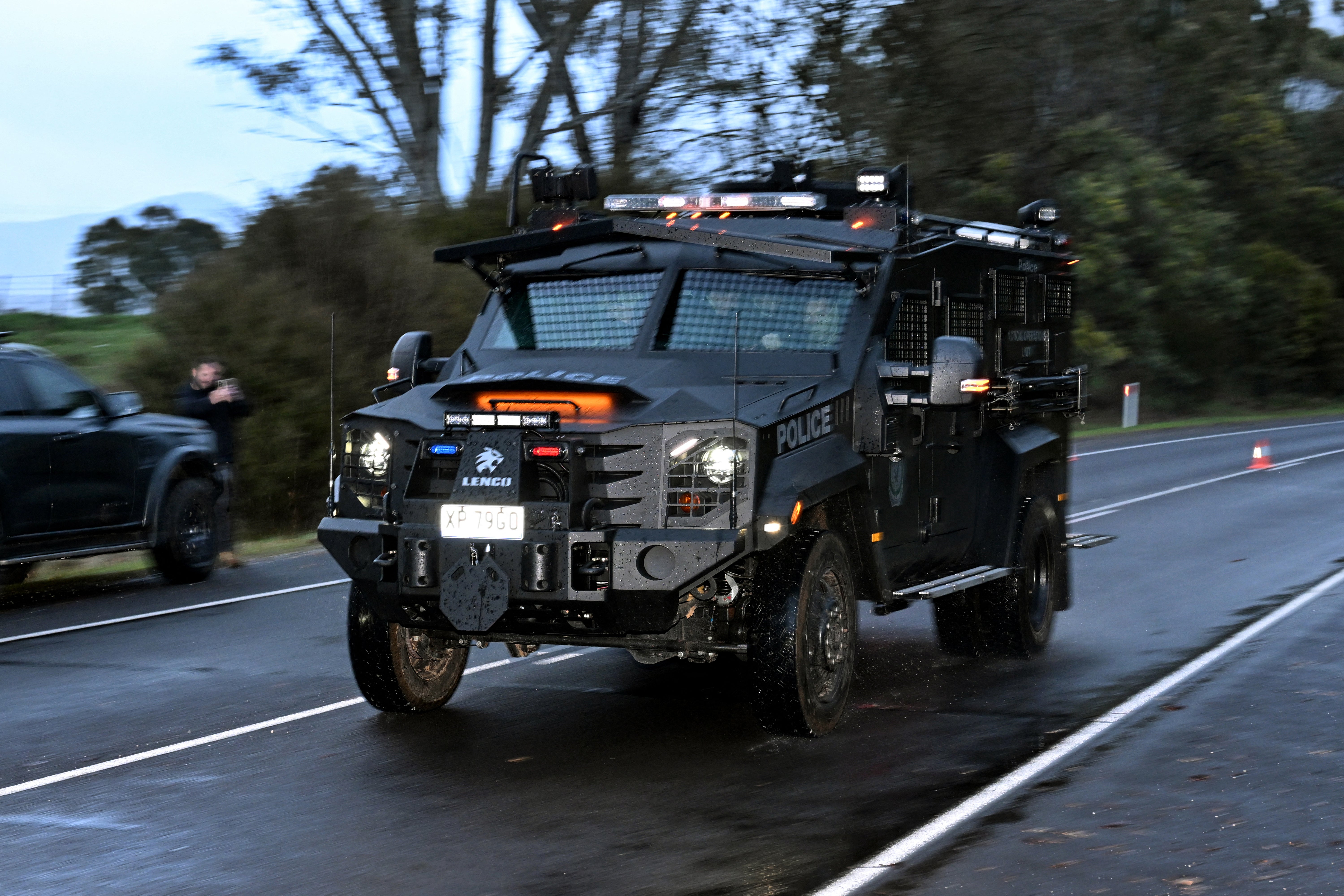 An armoured police vehicle passes through a roadblock during a search for a fugitive linked to the murder of two police officers in Porepunkah on 28 August 2025
