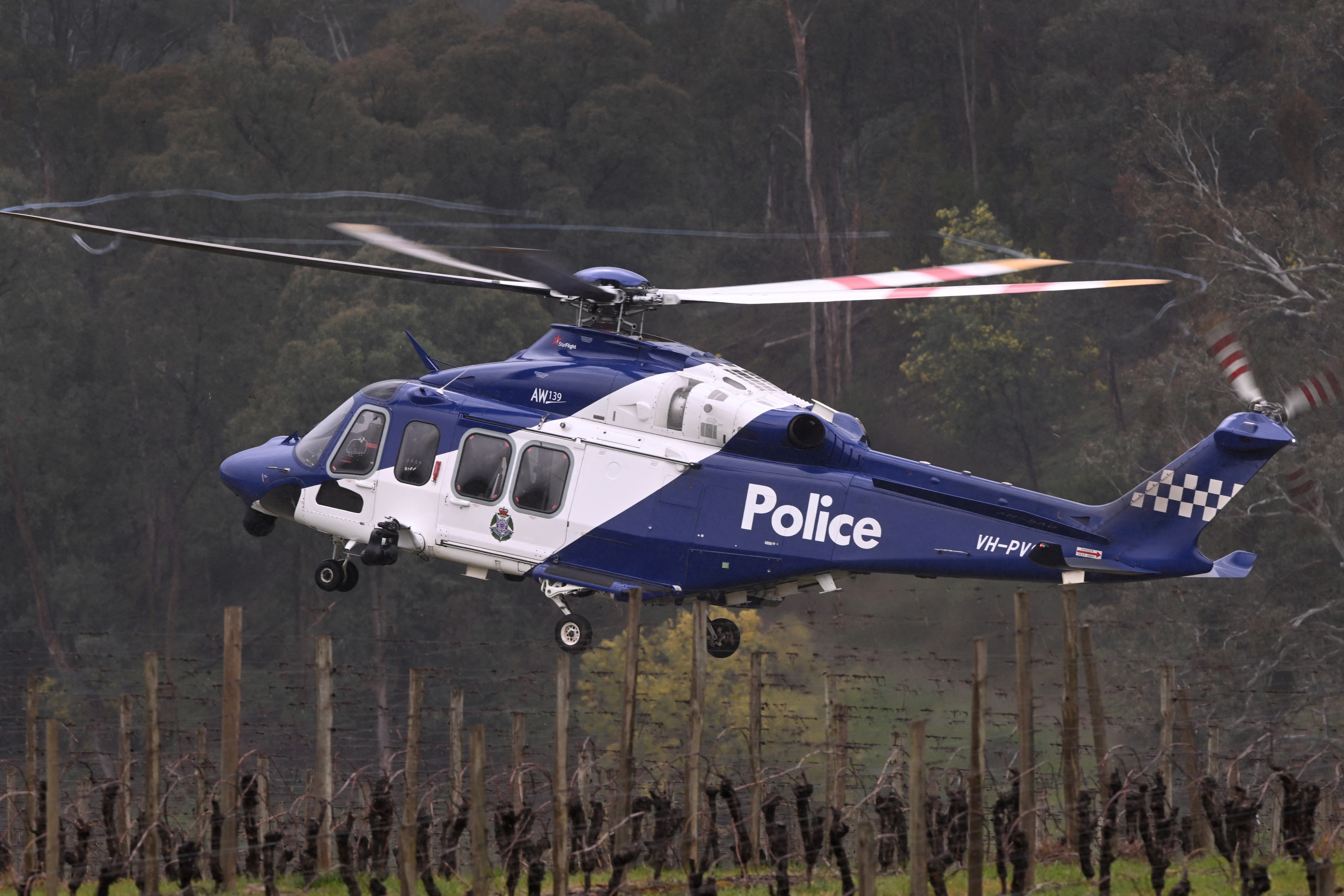 A police helicopter joins the search at a police staging point during the search for a fugitive linked to the murder of two police officers, in Porepunkah on 28 August 2025