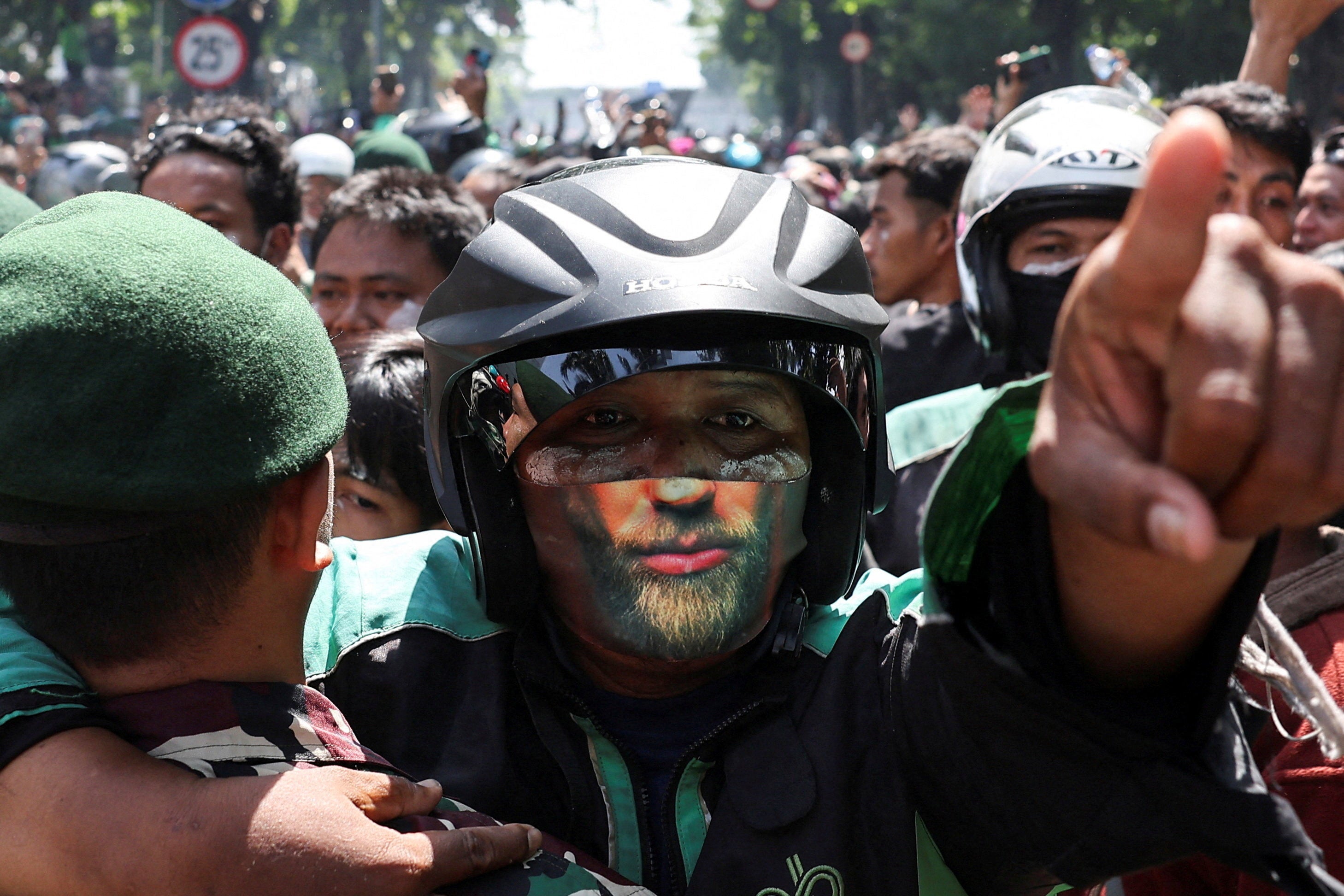 A demonstrator gestures at riot police outside Jakarta Mobile Brigade (Brimob) headquarters, during a clash after a motorcycle taxi driver died after being struck and run over by a police tactical vehicle during Thursday’s protest in Jakarta, Indonesia, 29 August 2025