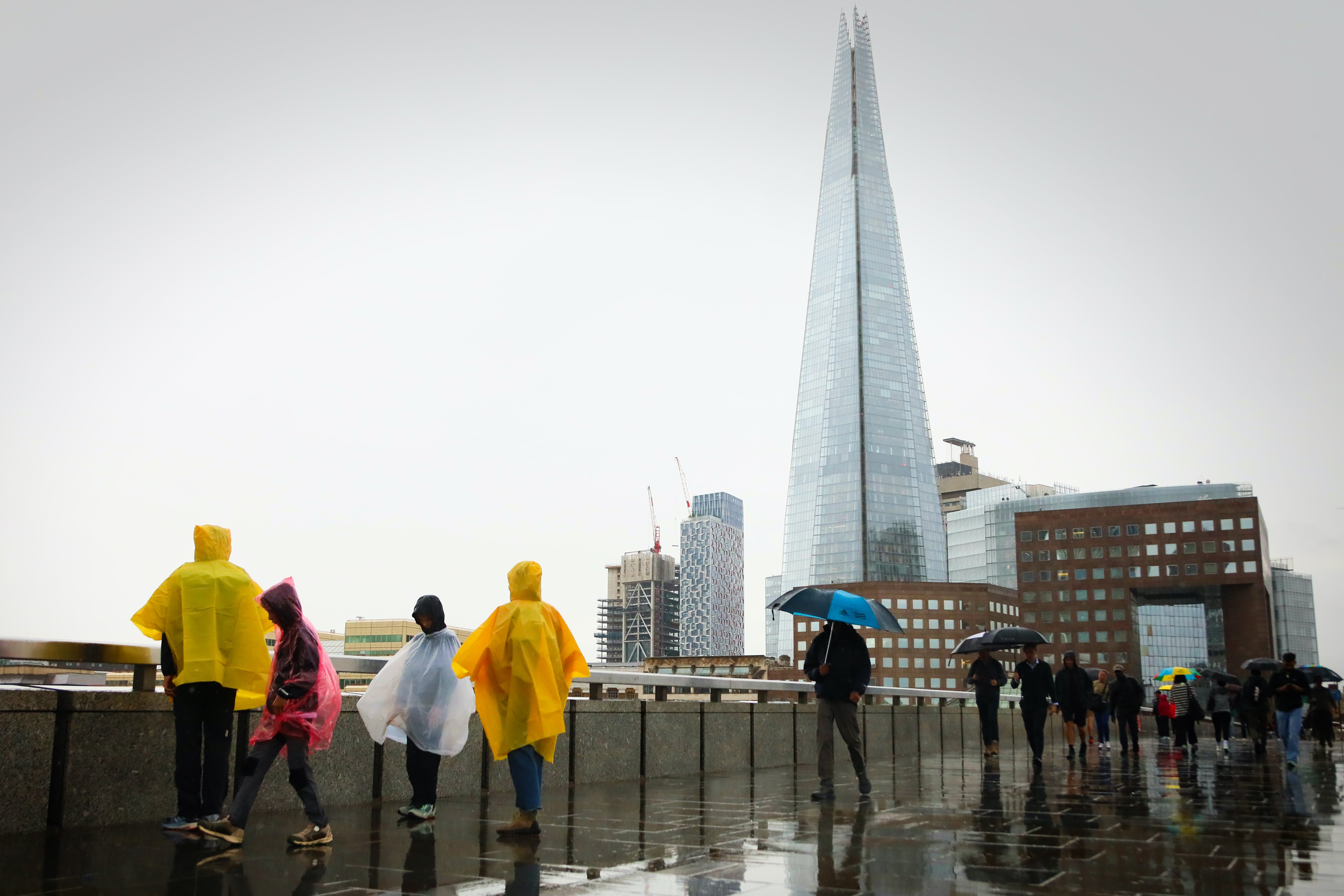 Members of the public walk through the rain over London Bridge on August 29, 2025 in London, England