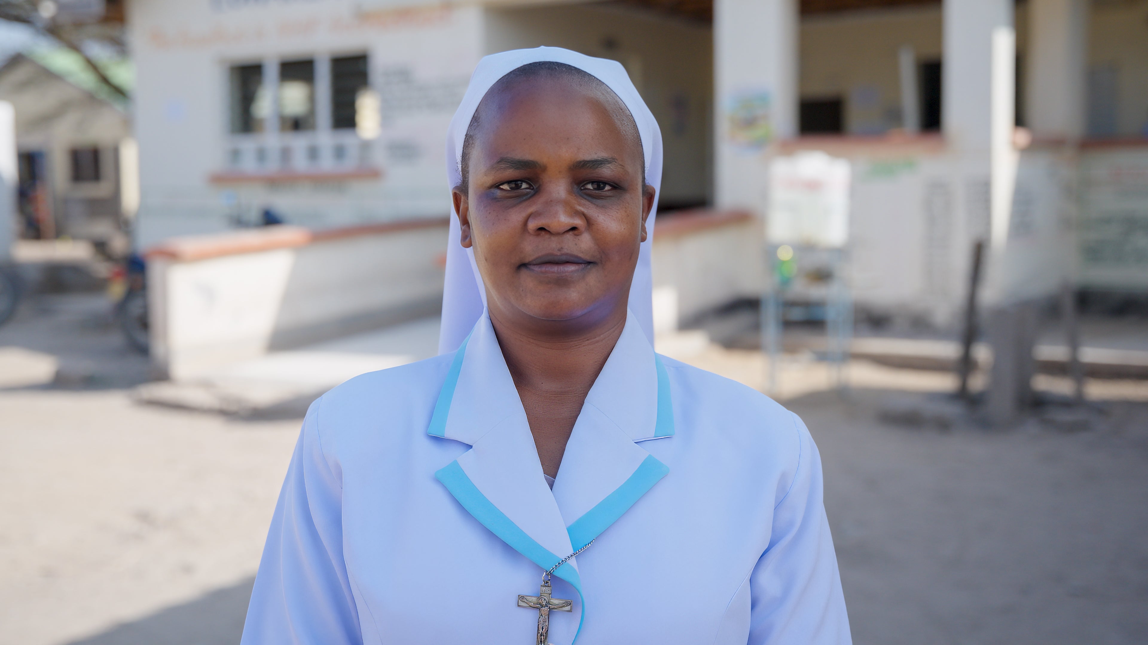 Portrait of Sister Winnie outside the health centre where she works, Turkana, Kenya. The clinic manager warned that the lives of children under her care will soon be under threat