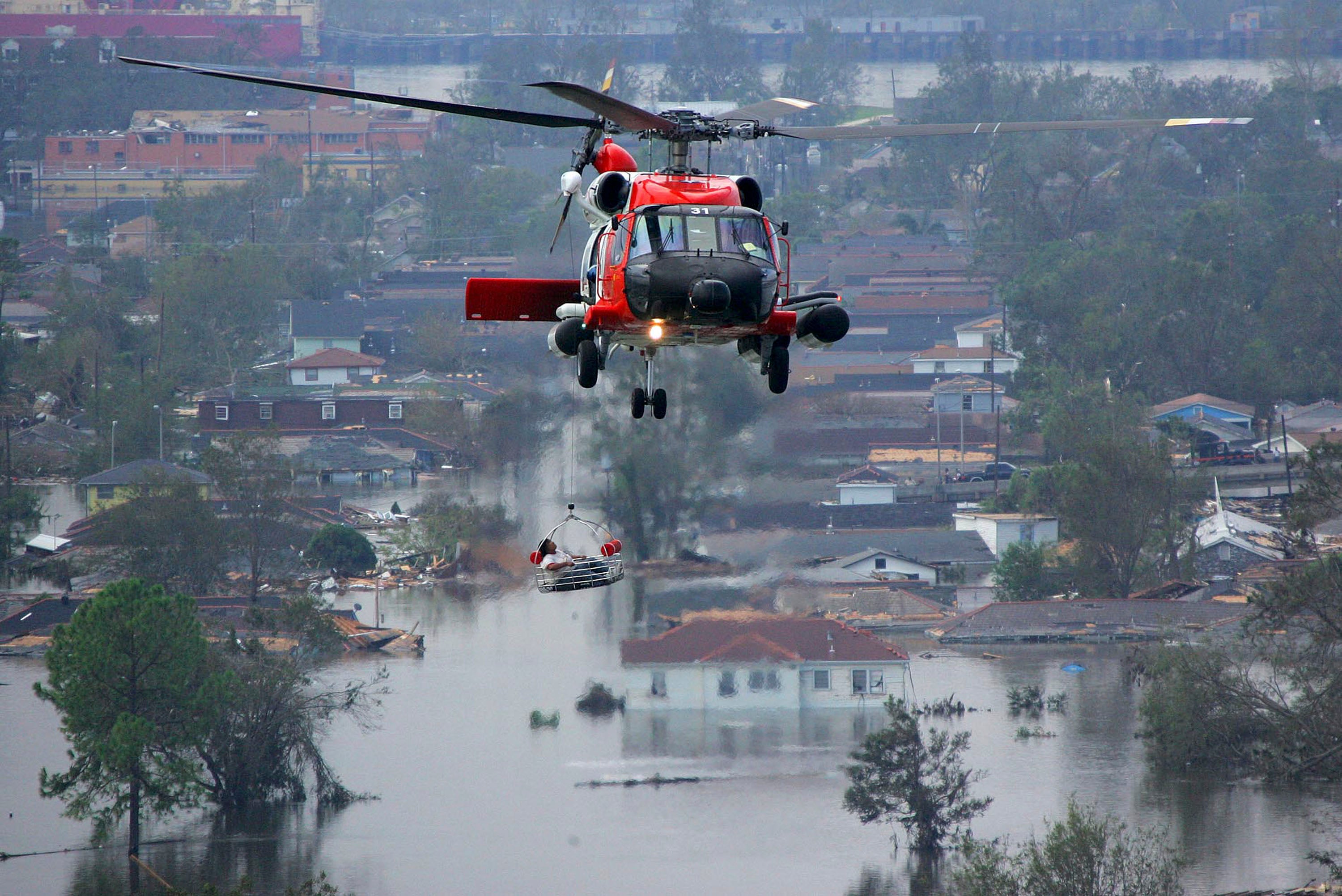 A person is lifted to safety by a Coast Guard helicopter in the aftermath of Hurricane Katrina
