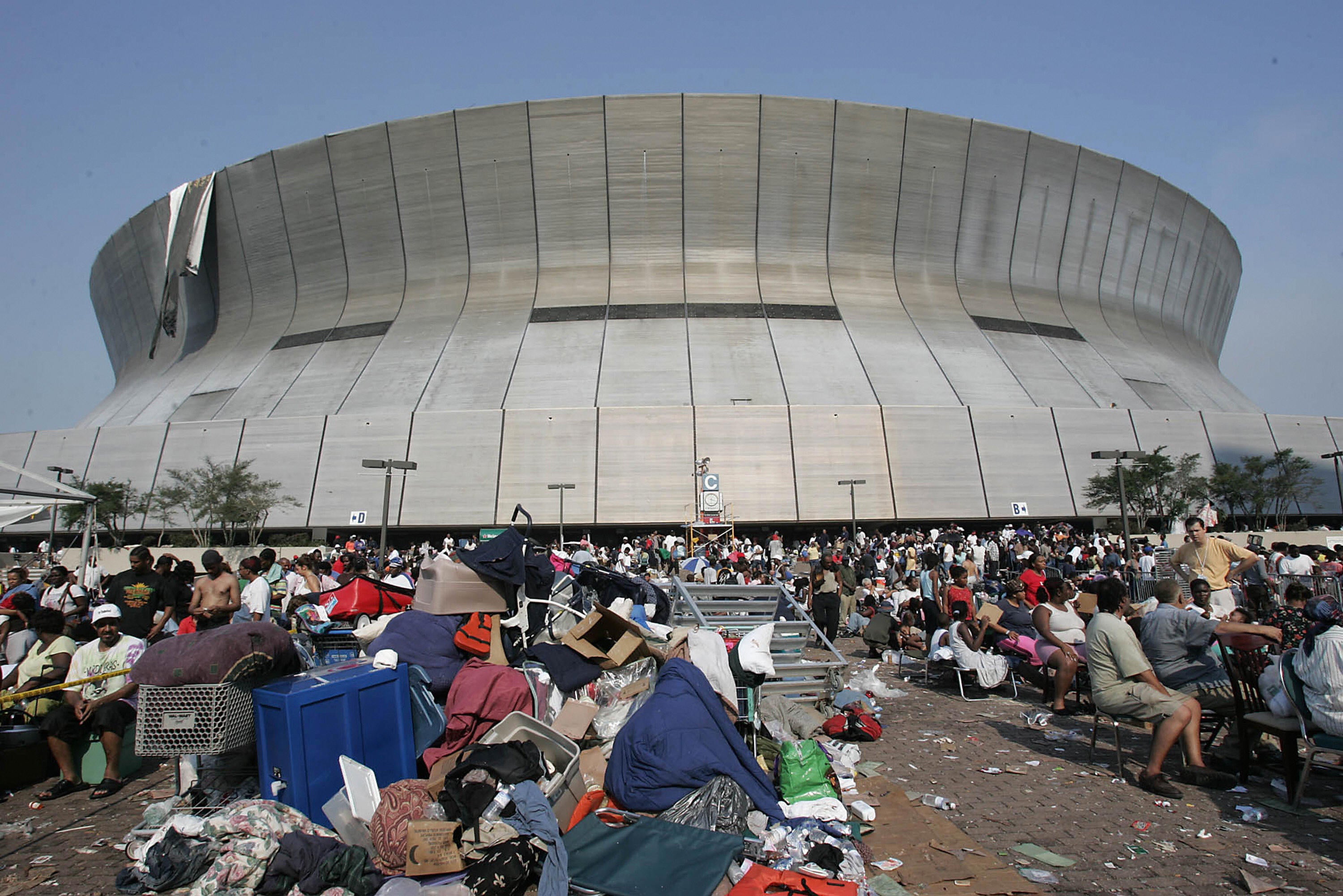 Hurricane Katrina survivors wait outside the New Orleans Superdome and Convention Center. The storm took the lives of nearly 1,400 people and left many without homes