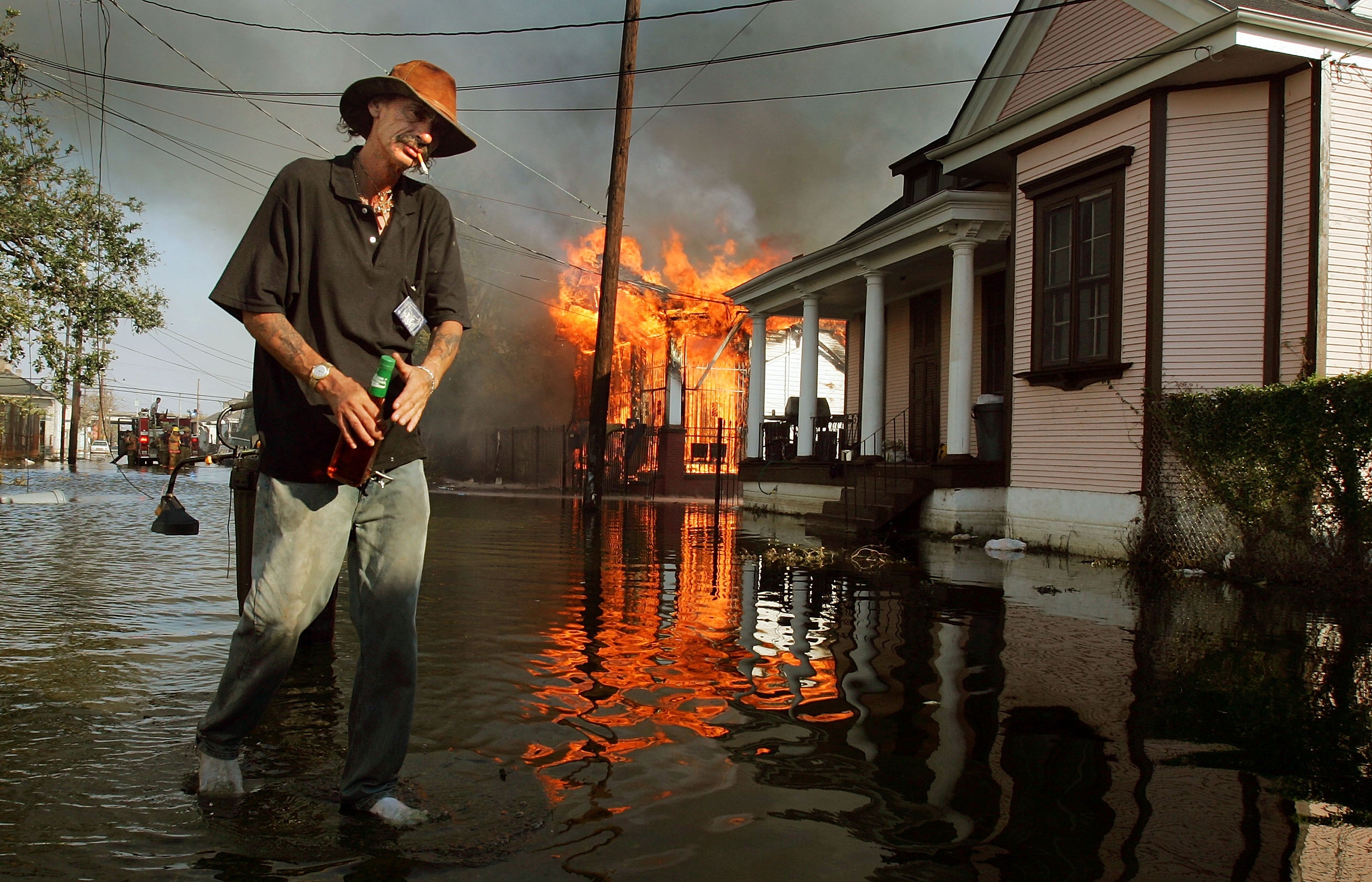 A resident walks past a burning house fire in the 7th ward September 6, 2005 in New Orleans, Louisiana
