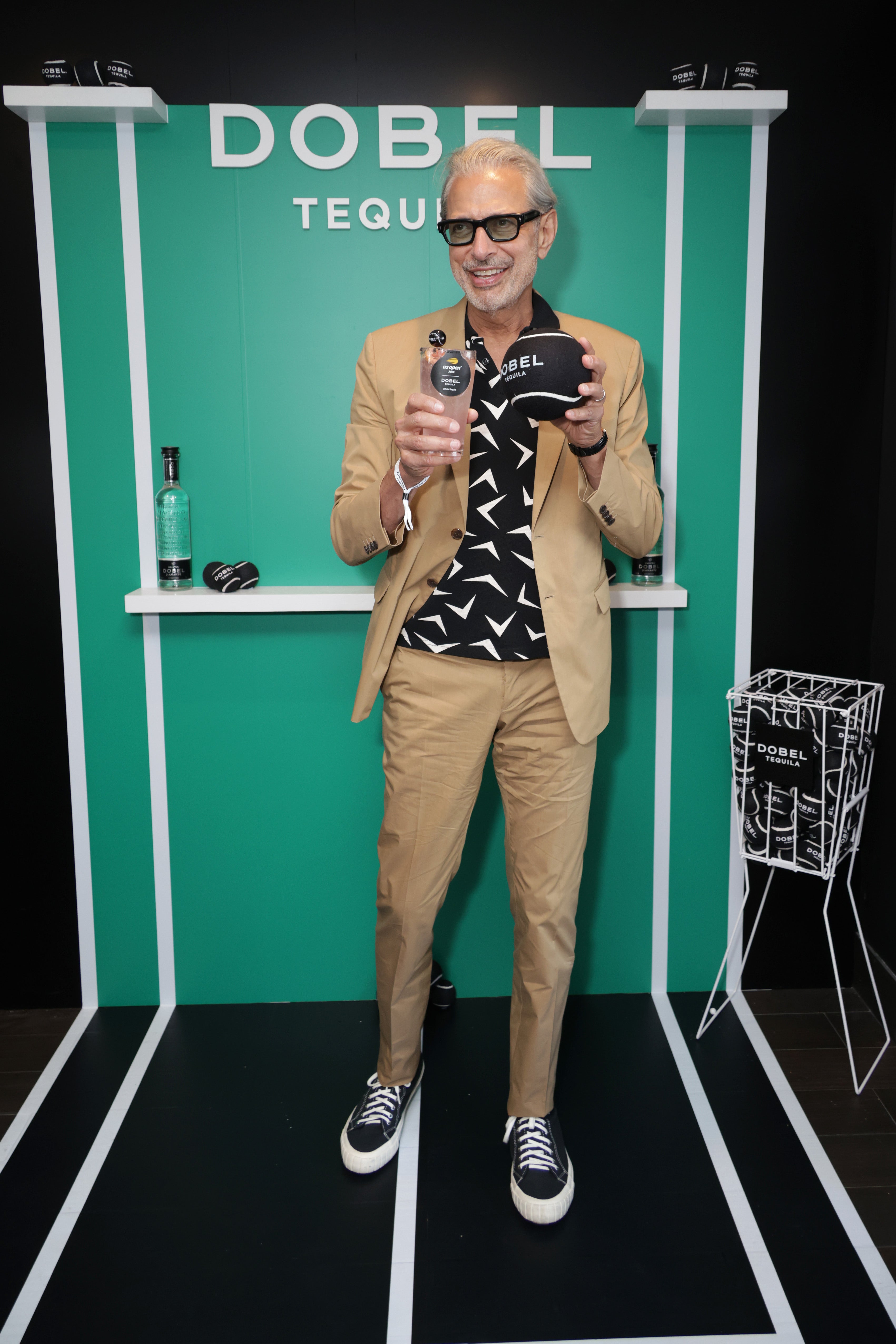 Jeff Golbum attended the US Open in style on August 25, wearing a tan jacket and matching pants, paired with a bold, black button-down and matching sneakers