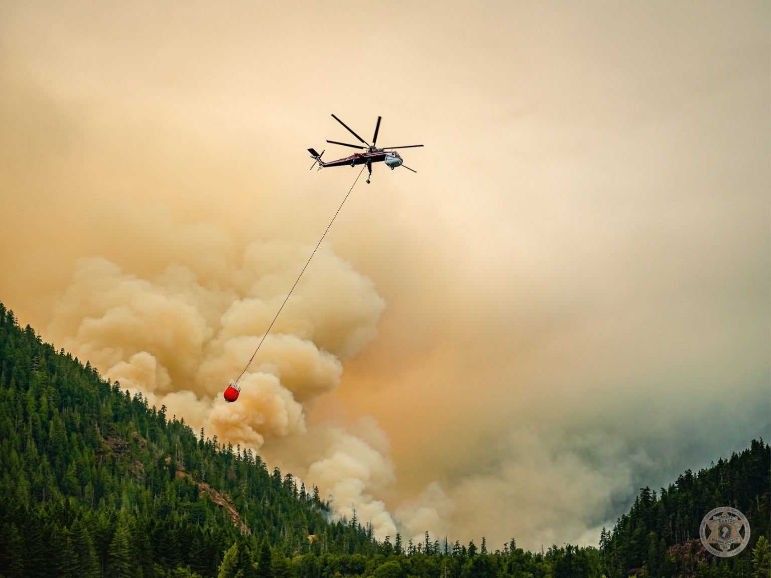 A helicopter drops water over the Bear Gulch Fire. The lawyers for a firefighter who U.S. border agents arrested are now demanding his release