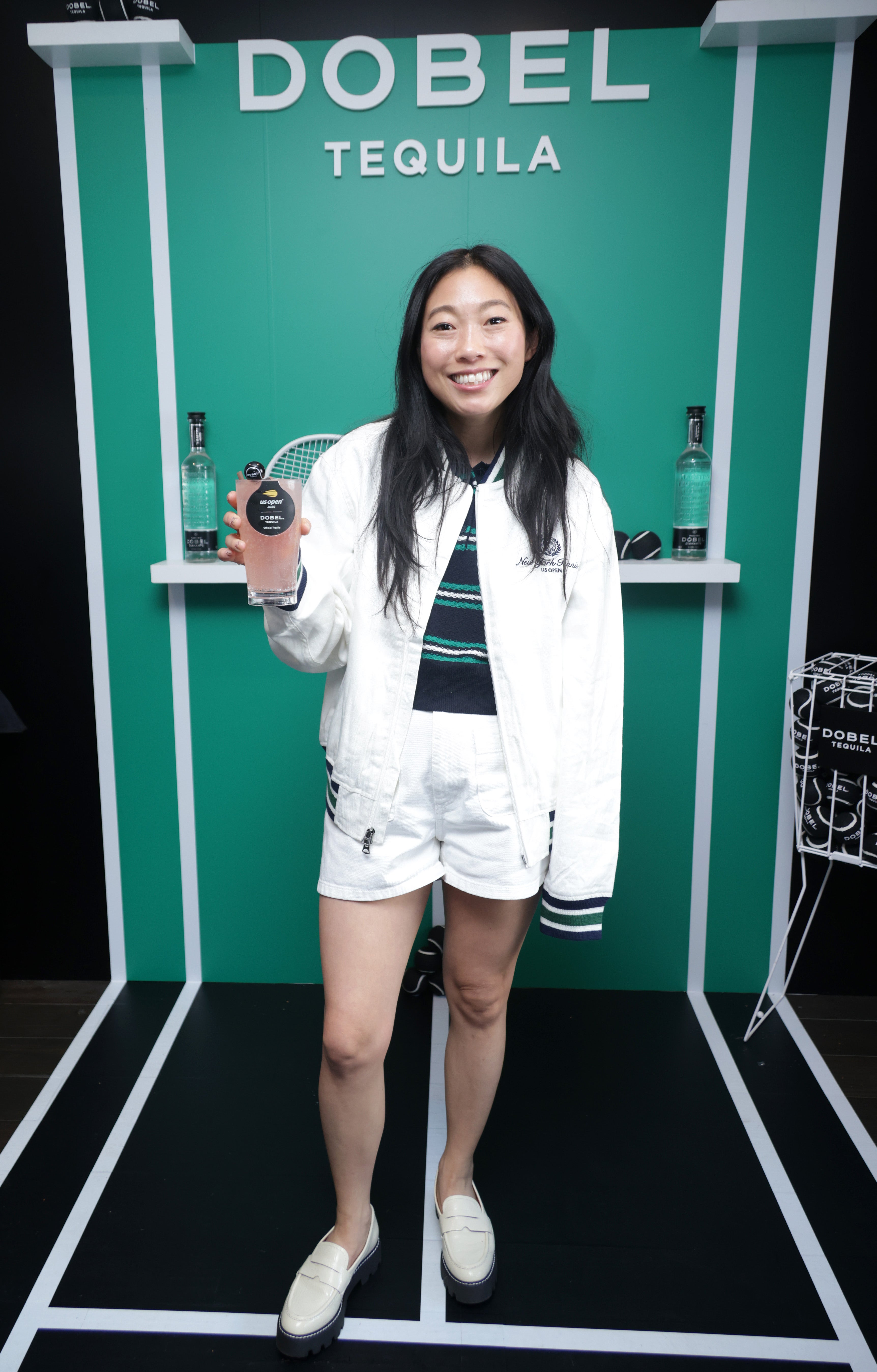 Awkwafina dressed to impress on August 27, wearing a white US Open tennis jacket and matching shorts. She also opt for a blue and green striped shirt and white flats