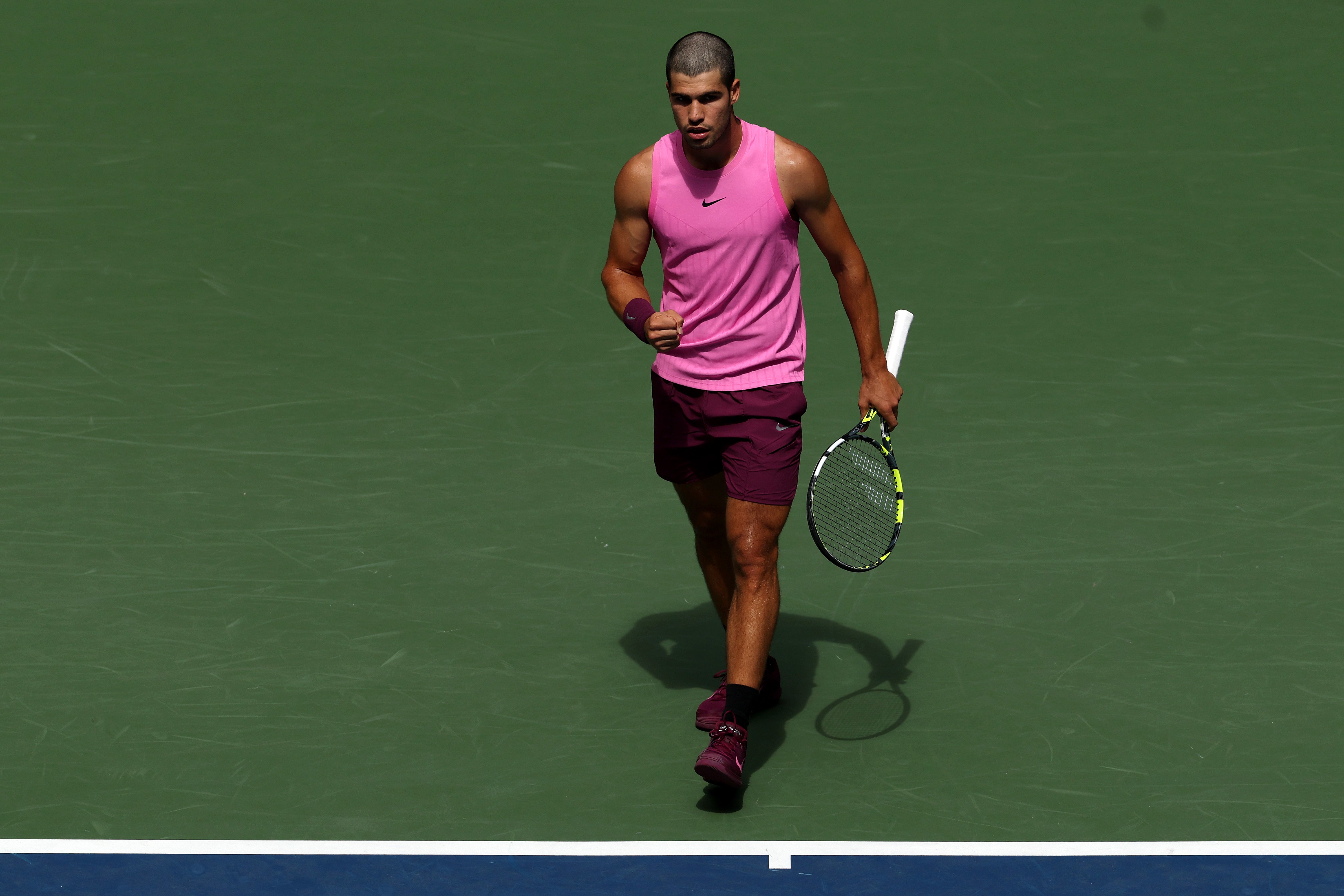 Carlos Alcaraz stepped onto the tennis court in a neon pink tank top and maroon shorts on August 29. Although he wore maroon sneakers to match, the light top and dark bottoms definitely clashed