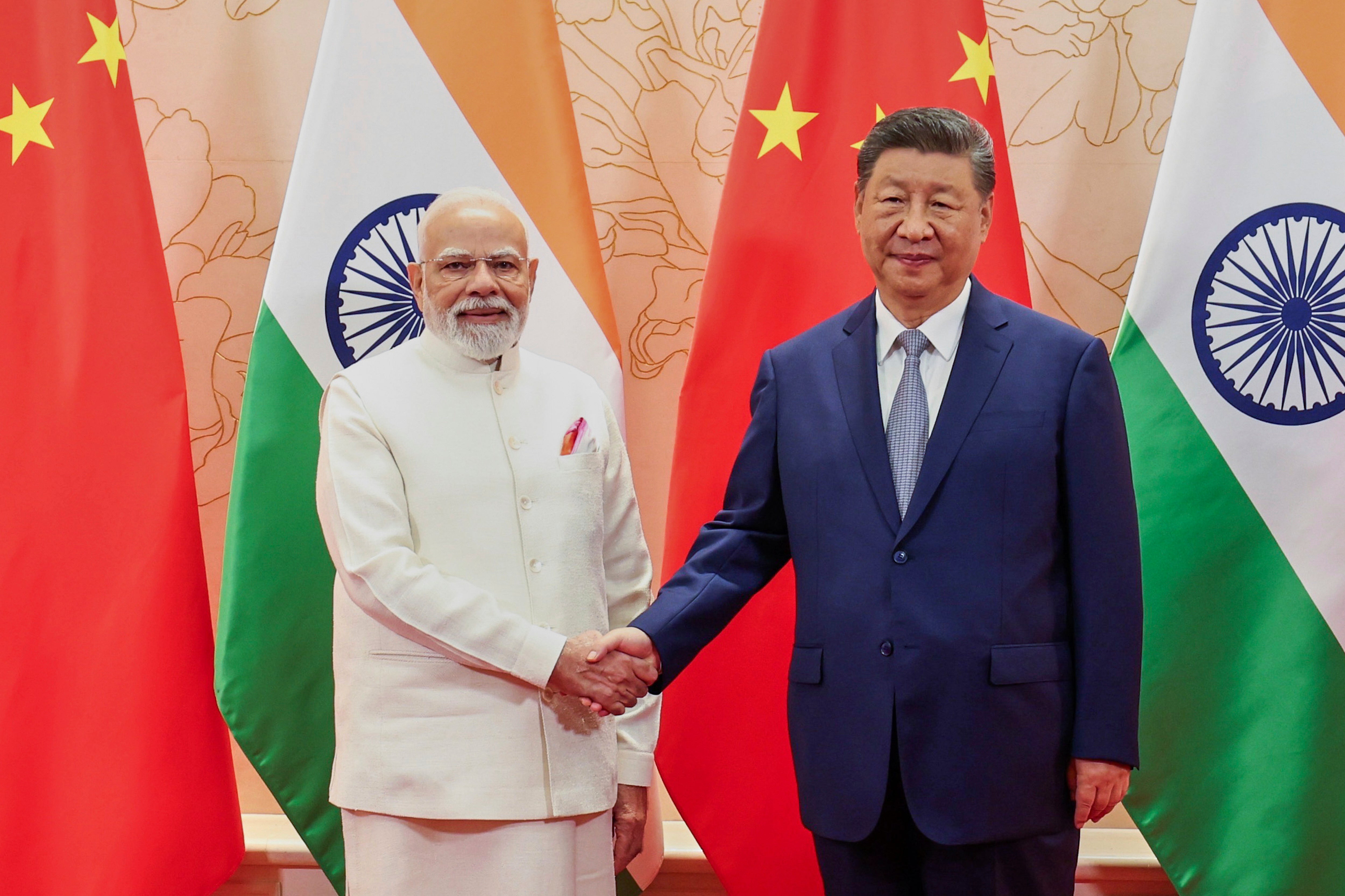 Indian Prime Minister Narendra Modi, left, and Chinese President Xi Jinping shake hand before their meeting