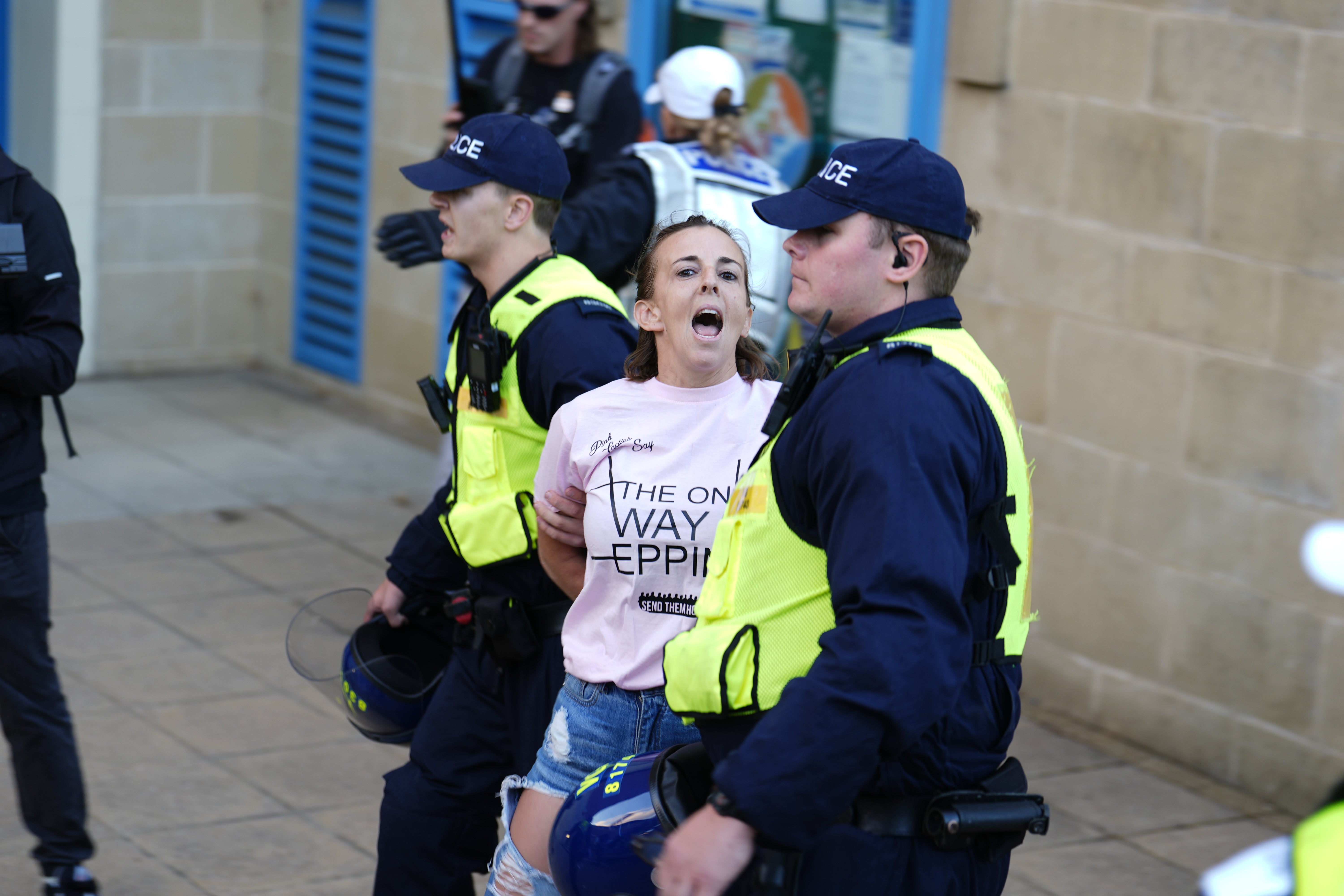 A protester is detained by police after hanging a Union flag from the civic offices