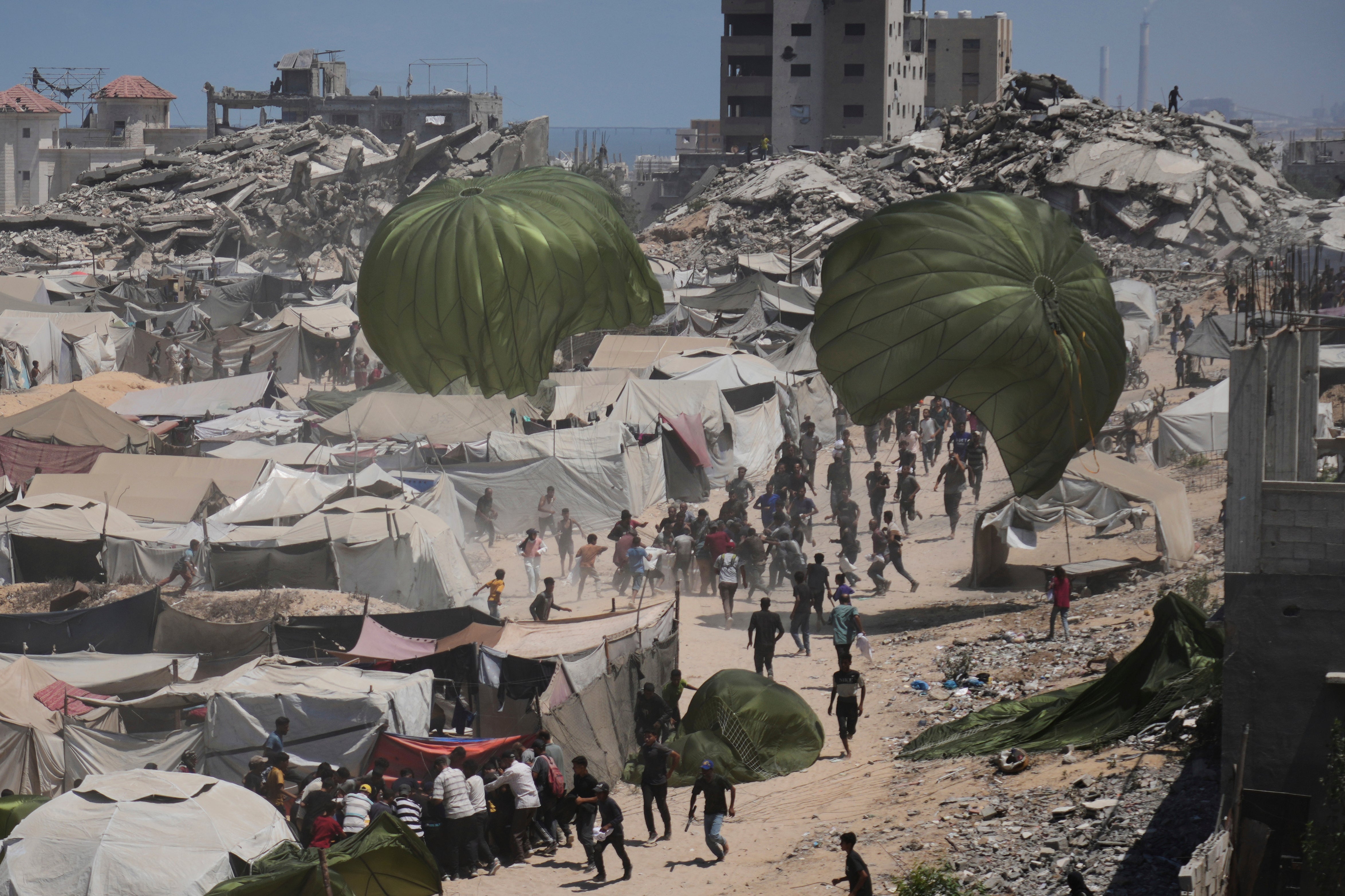 Palestinians rush to collect humanitarian aid airdropped by parachutes into Gaza City last month