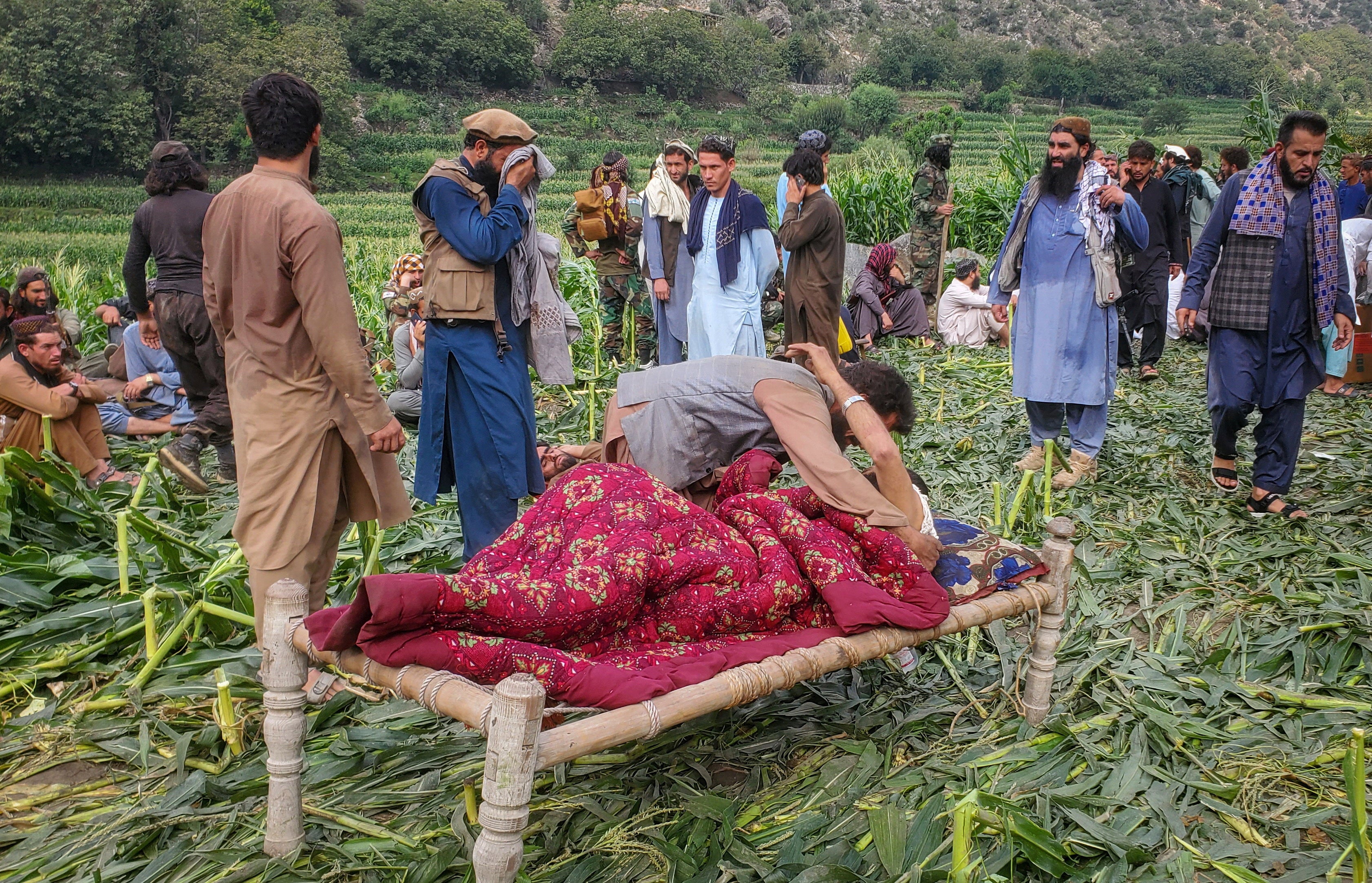 An Afghan man helps an injured person after the devastating earthquake