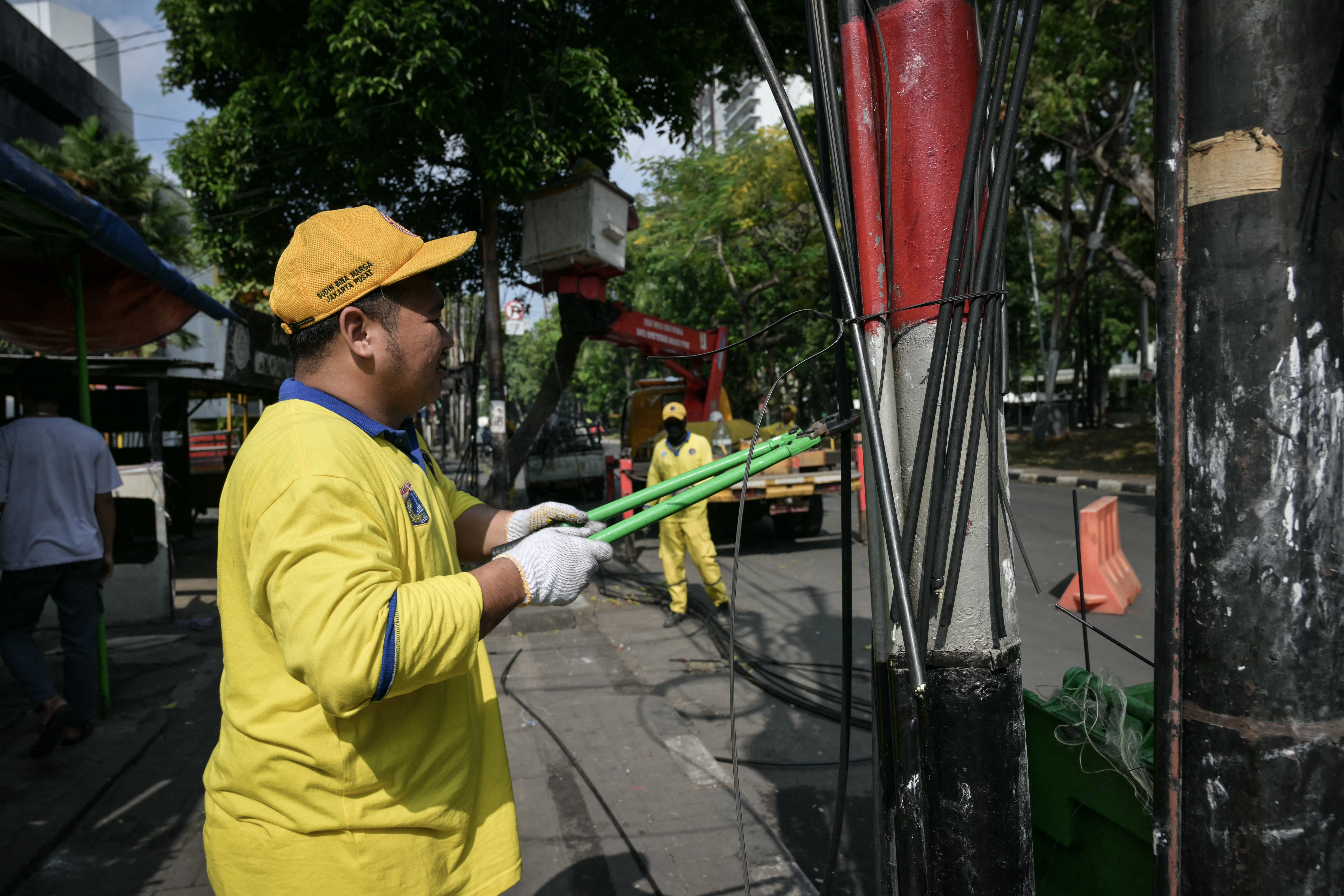 Road infrastructure task force members clear cables after being damaged by recent protests in Jakarta on 1 September 2025. Indonesian authorities ramped up security on 1 September after six people were killed in unrest over economic hardship that escalated into violent anger against the nation's police force