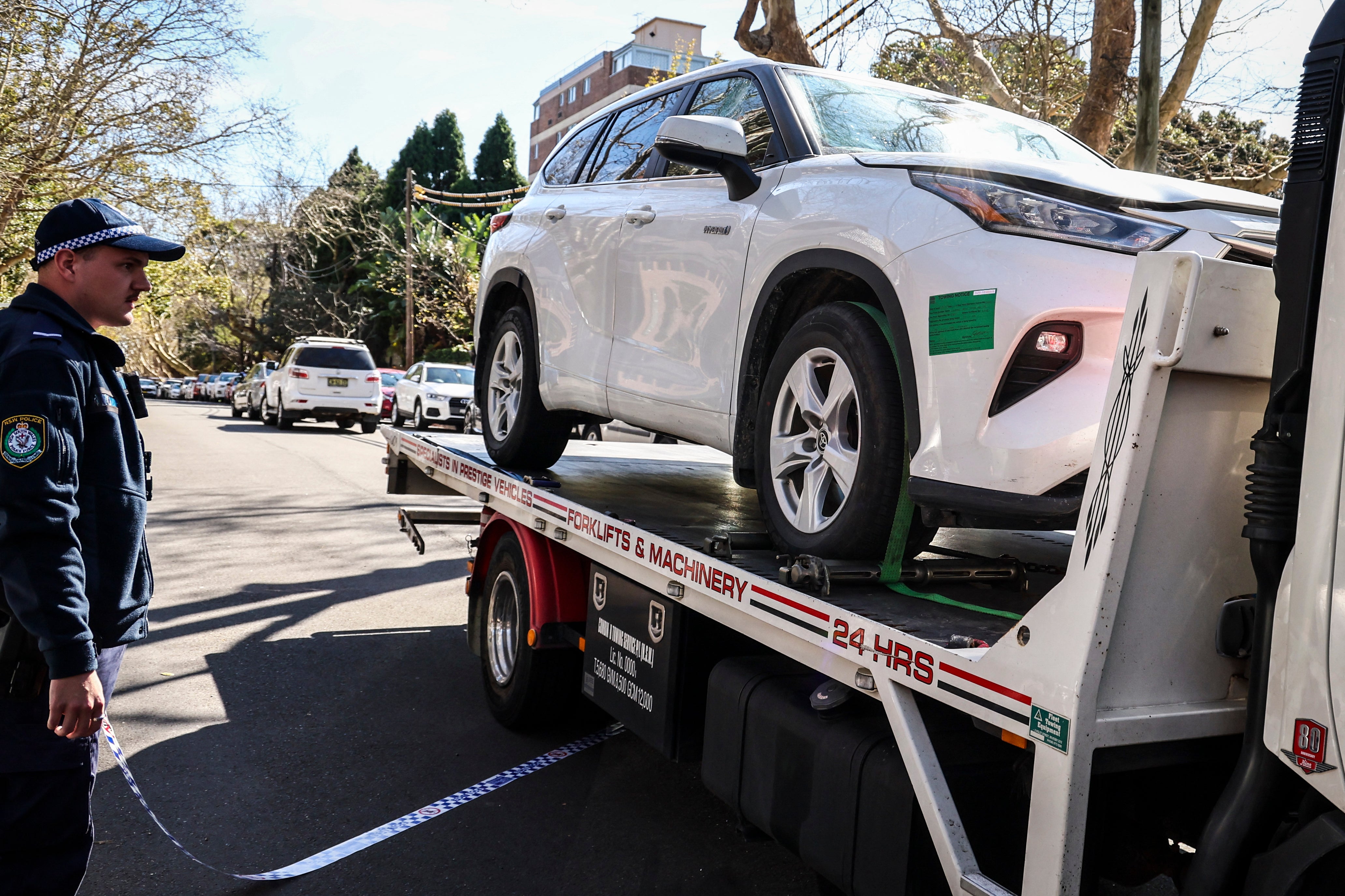 A police officer watches a tow truck as it removes a car that was driven into the gates of the Russian consulate in Sydney on 1 September 2025. New South Wales Police said they were called to the Russian consulate after reports that an unauthorised vehicle was parked in the driveway. Officers attempted to speak to the driver, who then allegedly 'drove his vehicle into the gates of the property', police said in a statement