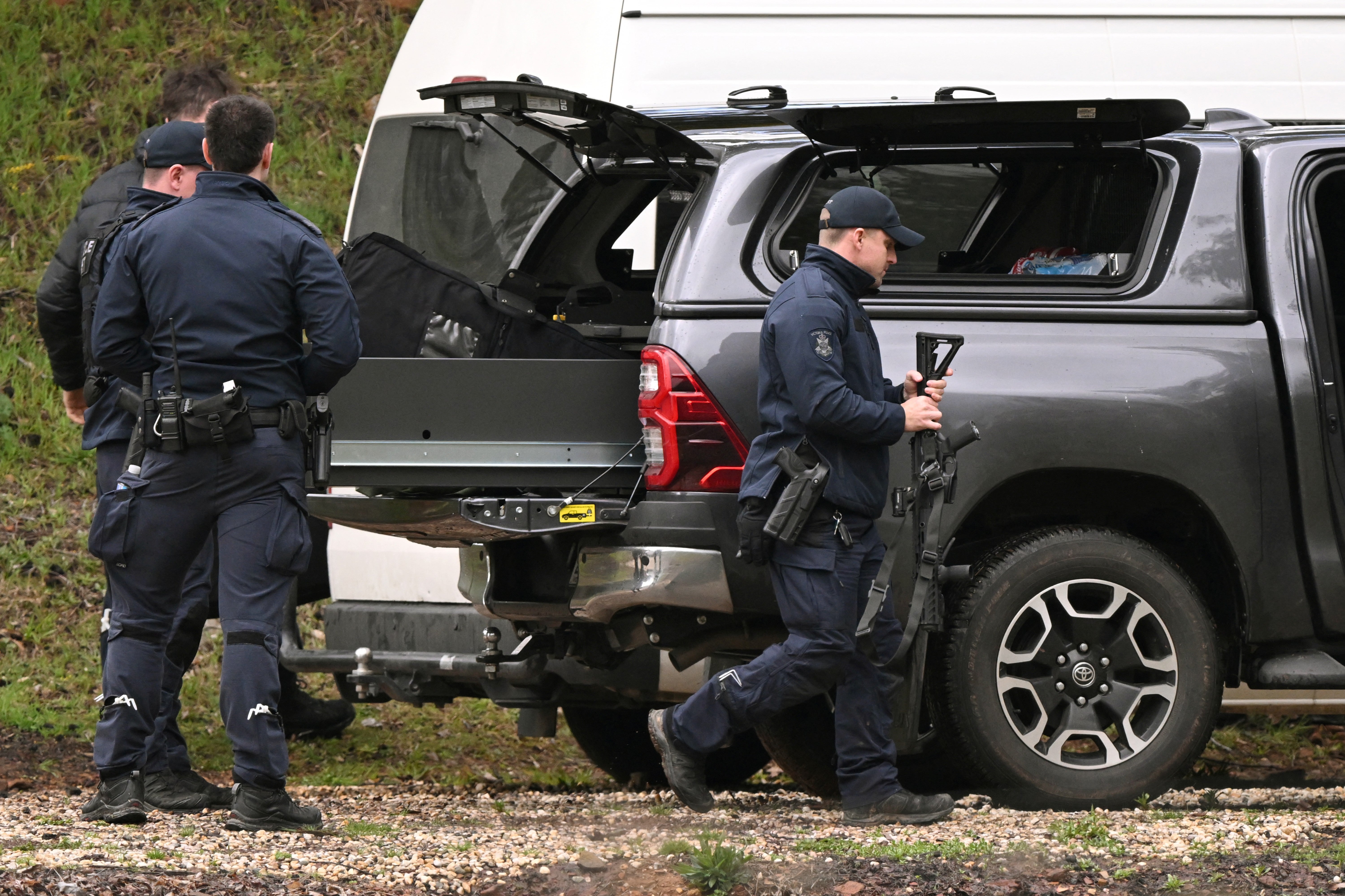 Heavily armed police gather at a staging point during a search for a fugitive linked to the murder of two police officers, in Porepunkah on 29 August 2025