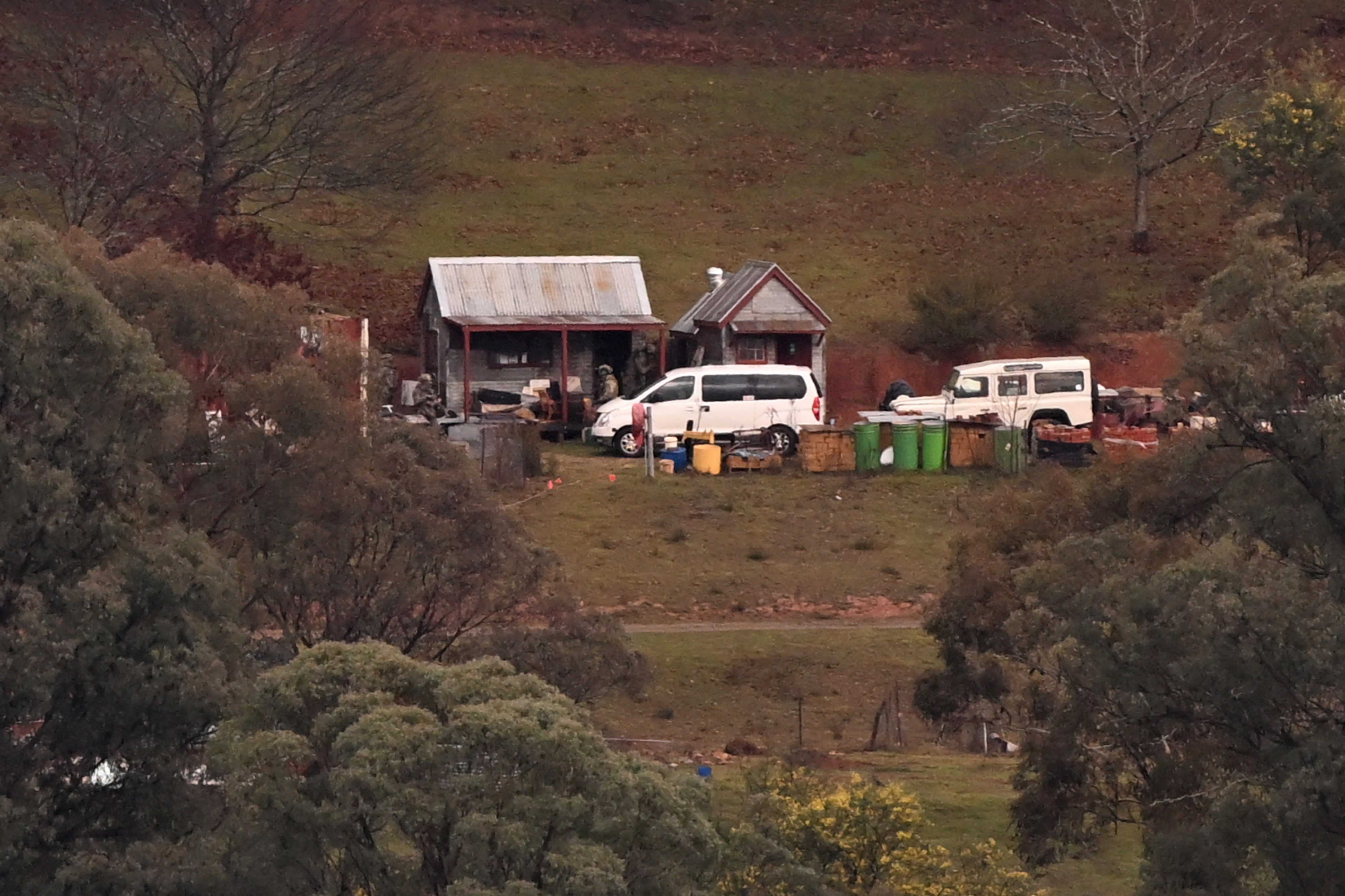 Armed police search a building on a property of interest during the search for a fugitive linked to the murder of two police officers in Porepunkah, Australia, on 29 August 2025