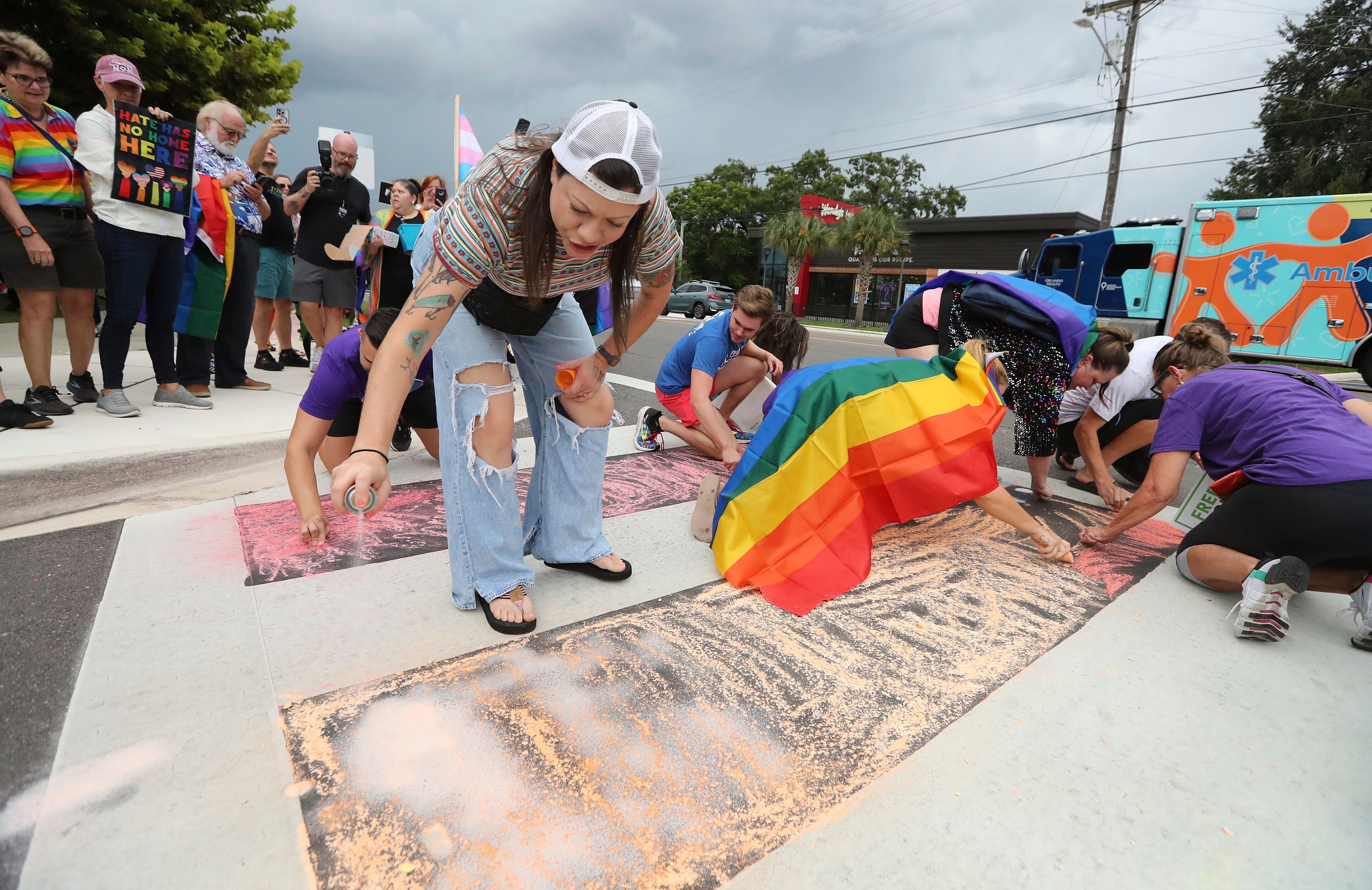 Demonstrators use chalk to color the street during a protest at the Pulse memorial crosswalk in Orlando, Florida, on August 21