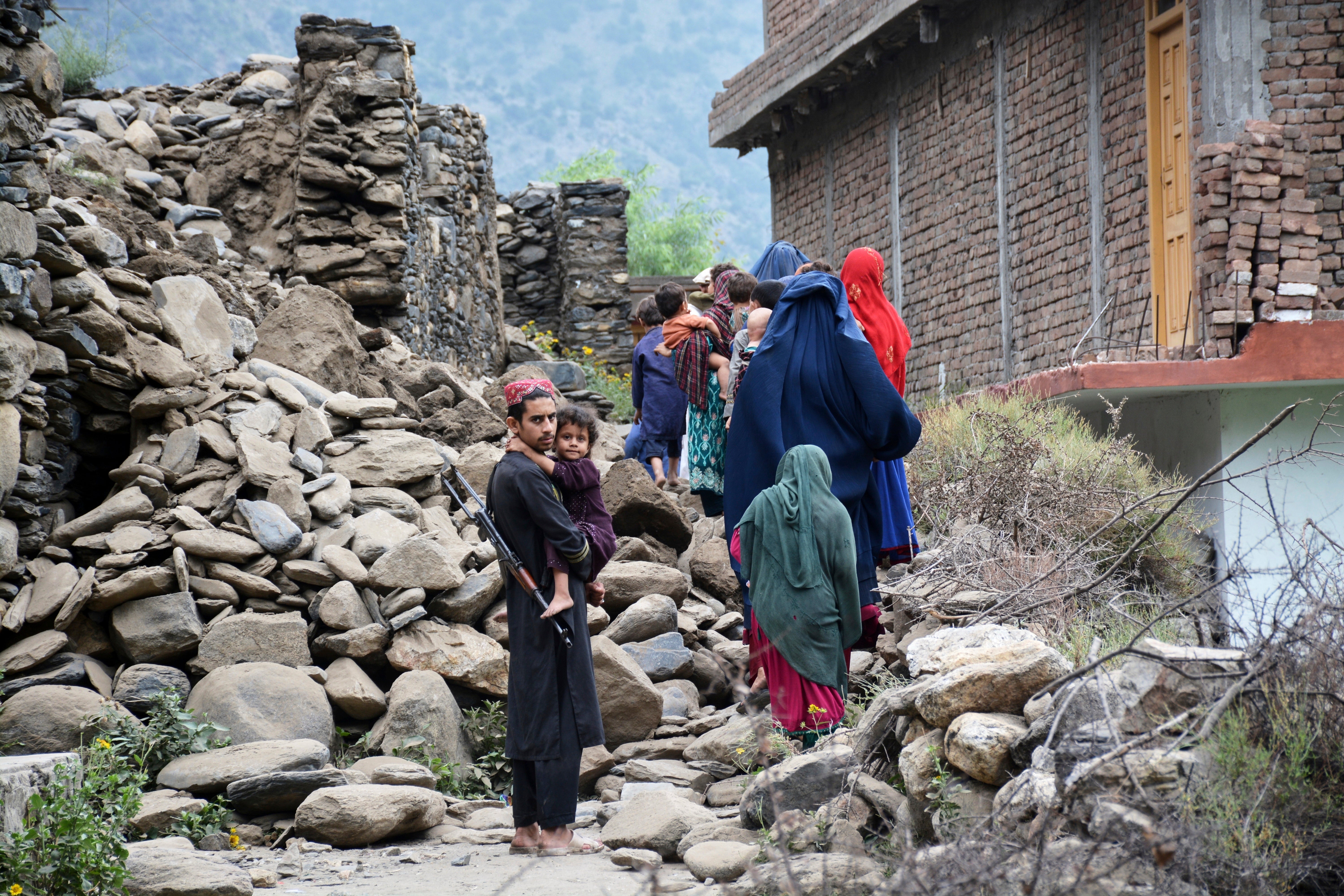 Afghans walk by a house destroyed by an earthquake in Mazar Dara village on 1 September 2025