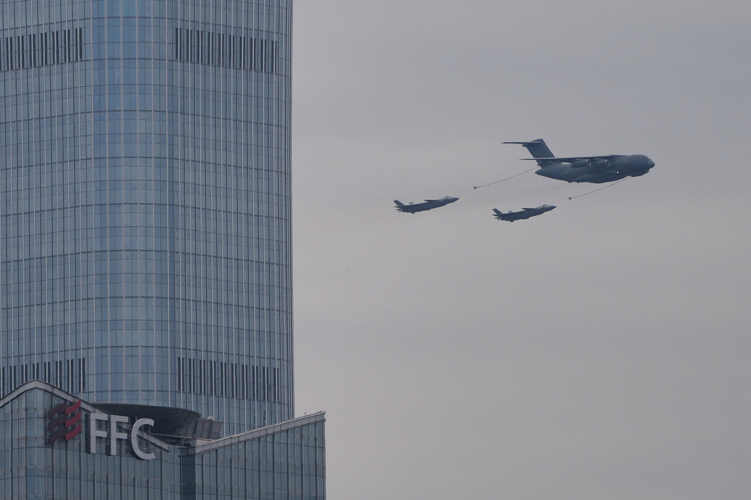 A Chinese YU-20 aerial tanker and J-20 stealth fighter jets fly past the capital city tallest skyscraper China Zun Tower and office buildings in the central business district during a rehearsal ahead of the Sept. 3 military parade to commemorate the 80th anniversary of Japan's World War II surrender, in Beijing on Aug. 24, 2025. (AP Photo/Andy Wong)