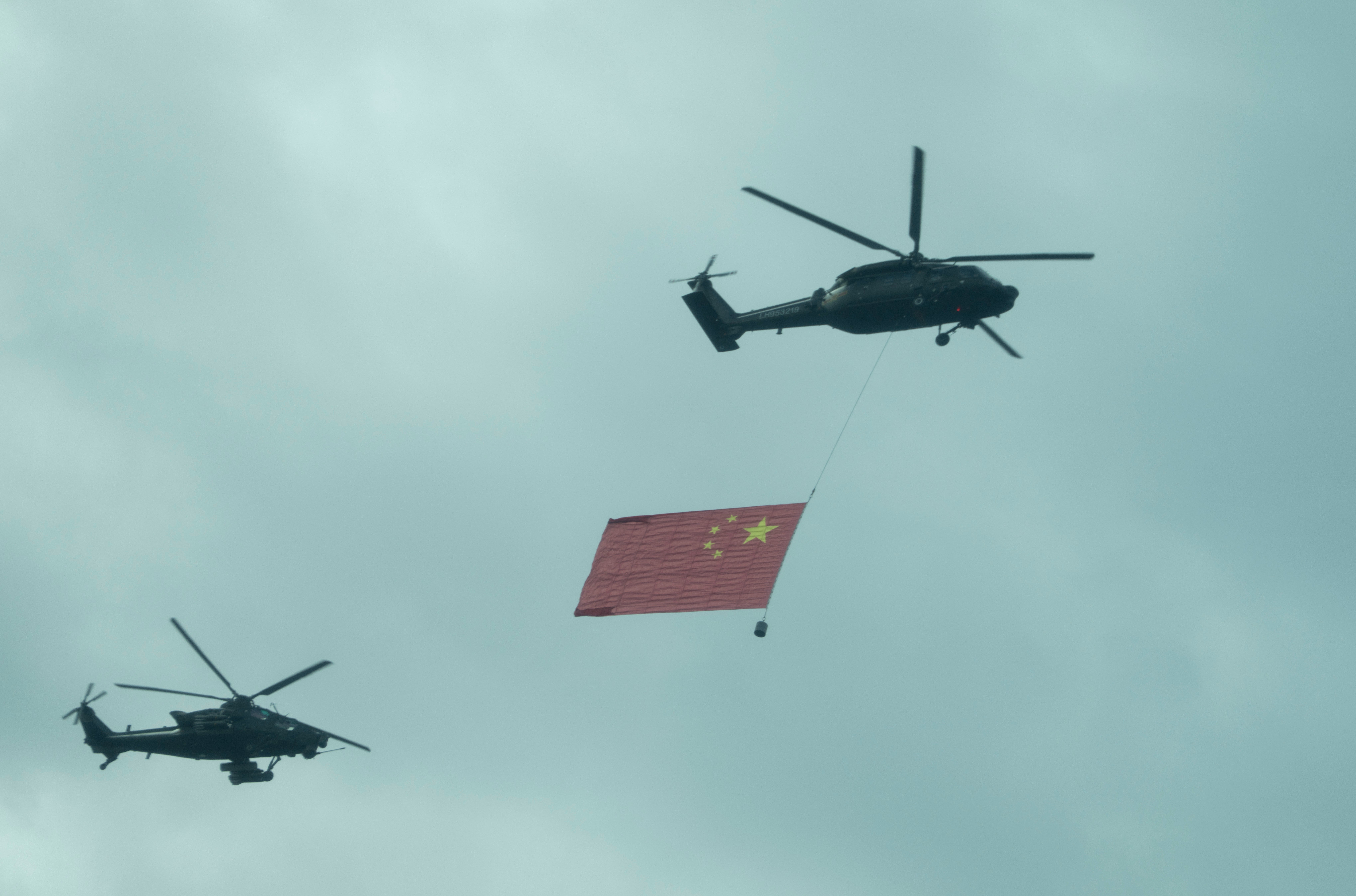 Chinese military helicopters fly over the central business district during a rehearsal ahead of the Sept. 3 military parade to commemorate the 80th anniversary of Japan's World War II surrender, in Beijing on Aug. 24, 2025. (AP Photo/Ng Han Guan)