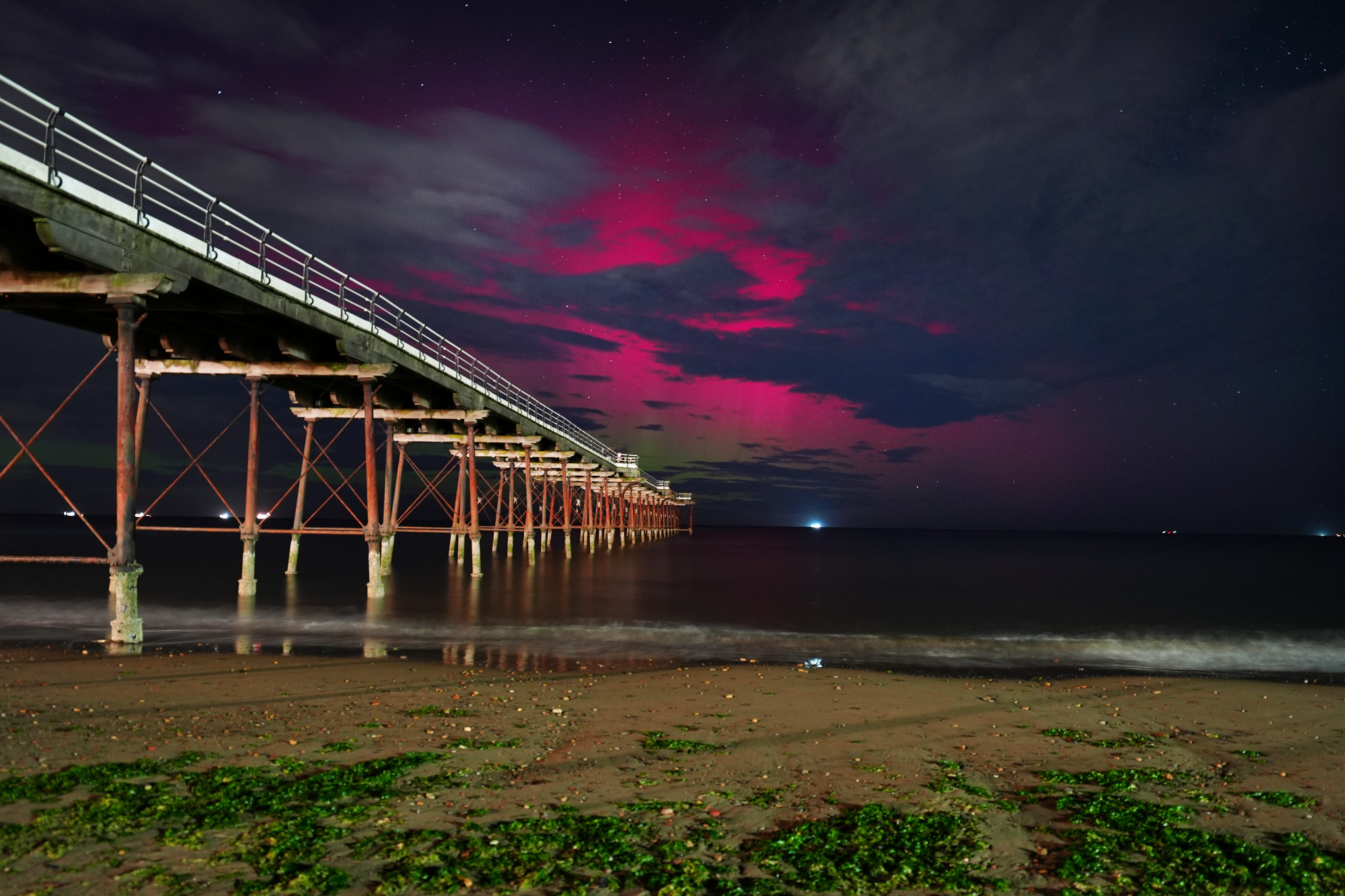 The Northern Lights visible through clouds over Saltburn-by-the-Sea in North Yorkshire on Tuesday morning (Owen Humphreys/PA)