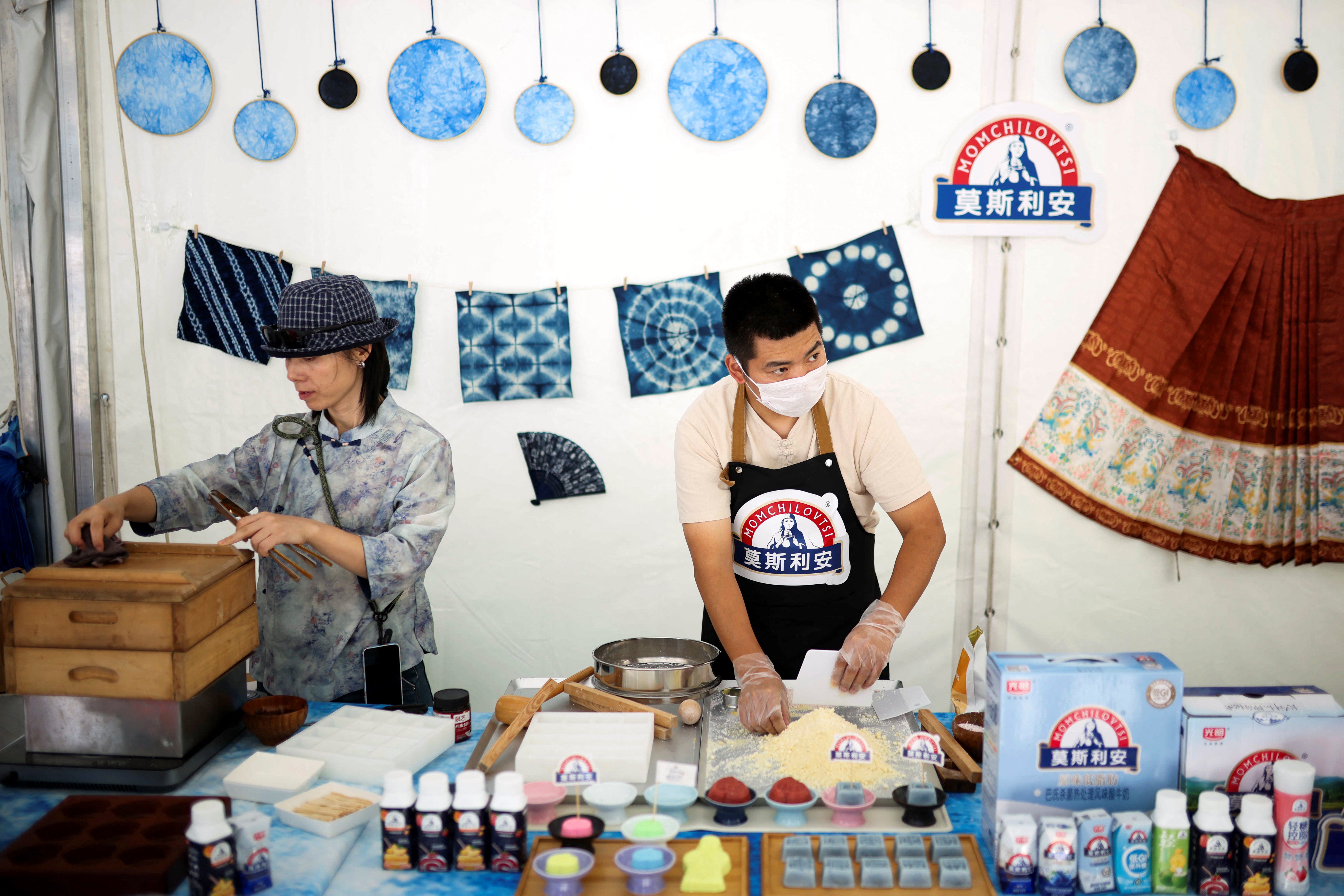 Chinese participants of the Yogurt Festival prepare a rice cake next to Chinese yogurt