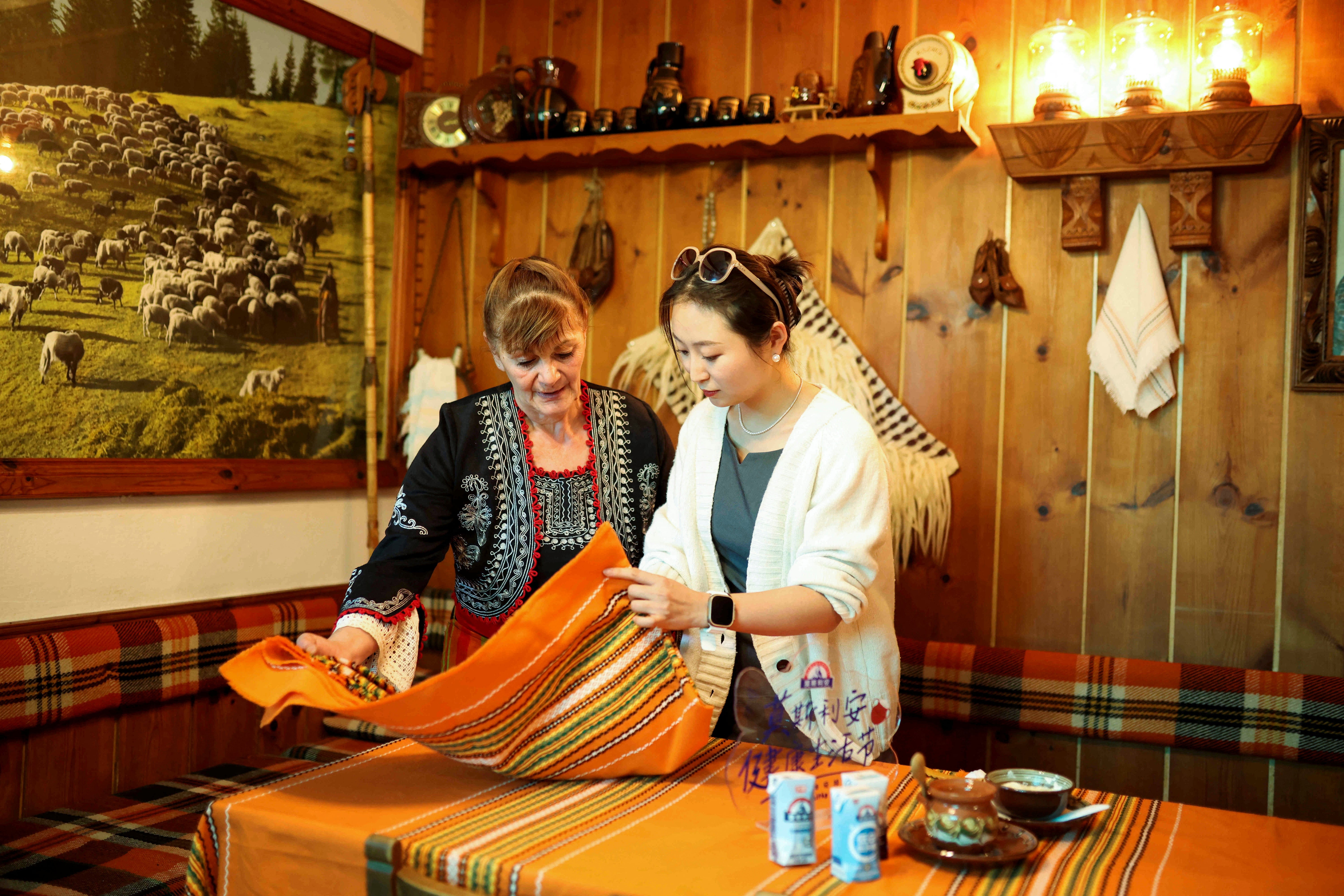 Rumiyana Cholakova, a local resident in the village of Momchilovtsi presents the process of yogurt making to a Chinese tourist in her home,