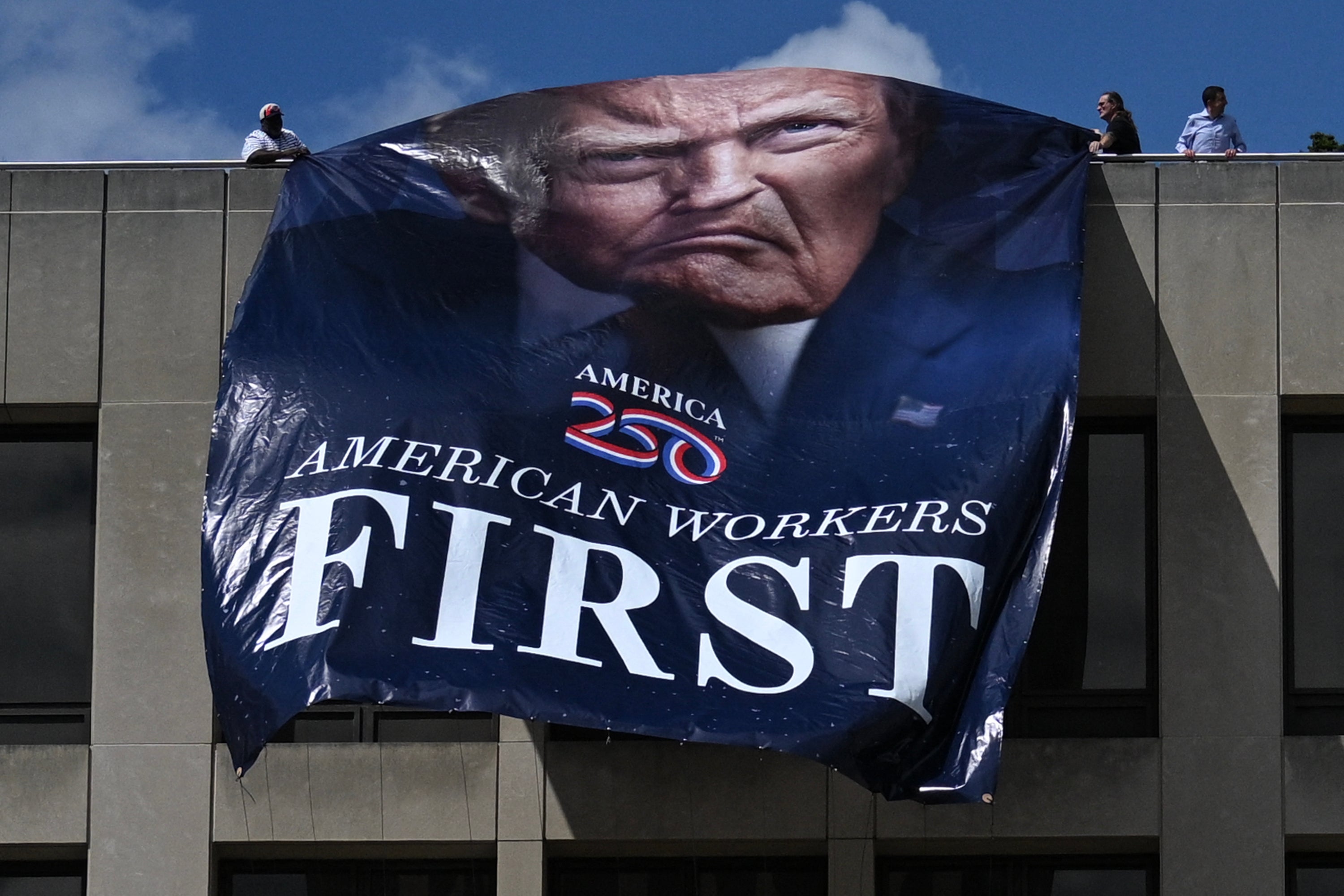 Workers unfurled an ‘American Workers First’ banner on the Department of Labor building in Washington, D.C., as Trump moved to cancel collective bargaining agreements with unions representing thousands of federal workers.
