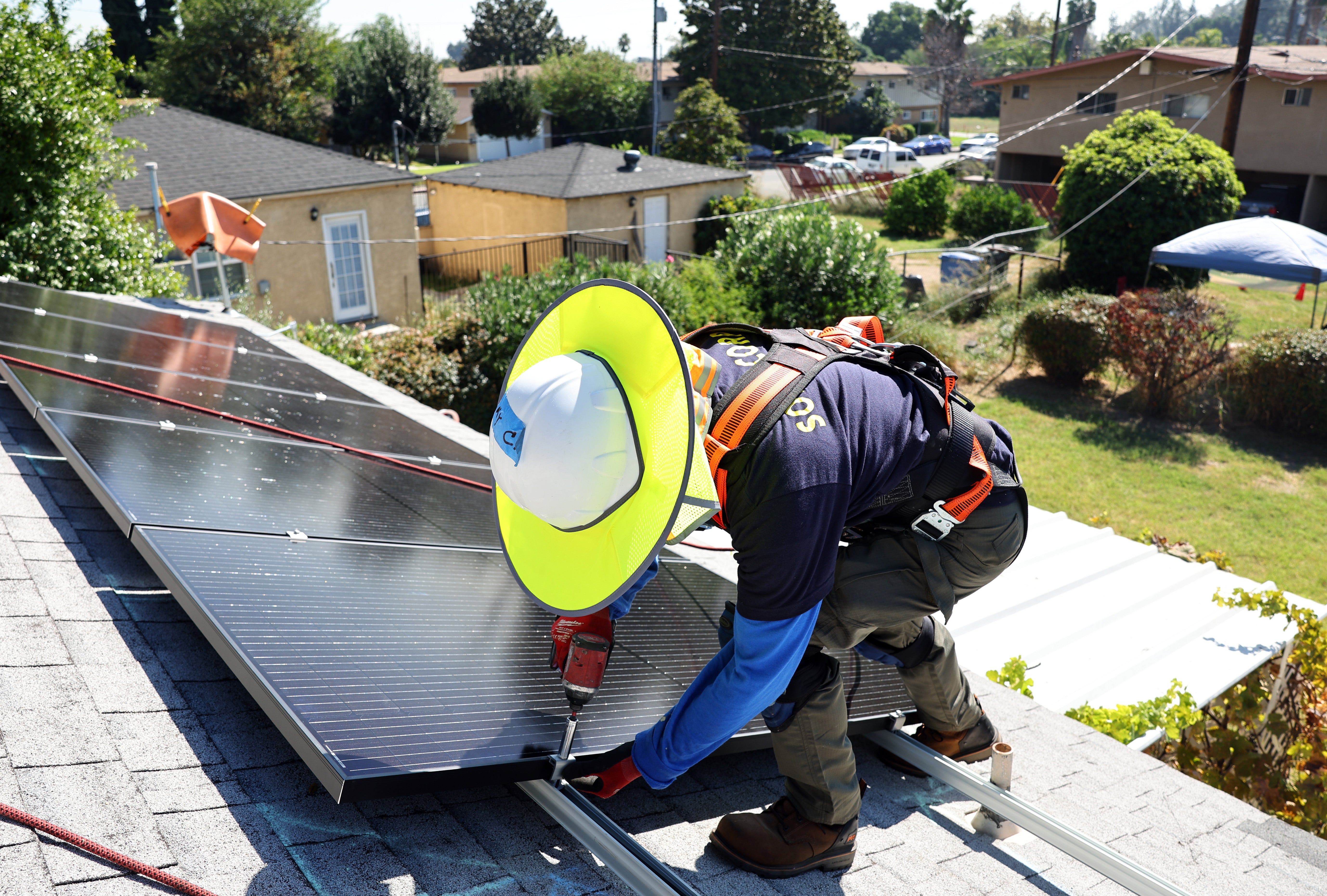 A man installs solar panels on the rooftop of a California home in October 2023. A federal appeals court cleared the way for the Trump administration to claw back $20 billion from a climate bank that would go toward solar panel installation and other clean energy