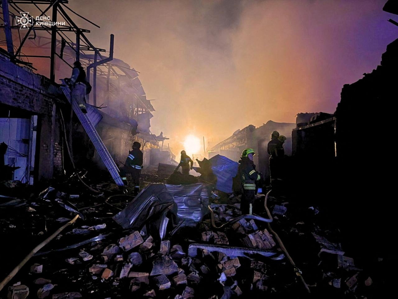 Firefighters working at the site of car garages hit by a Russian drone strike near Kyiv