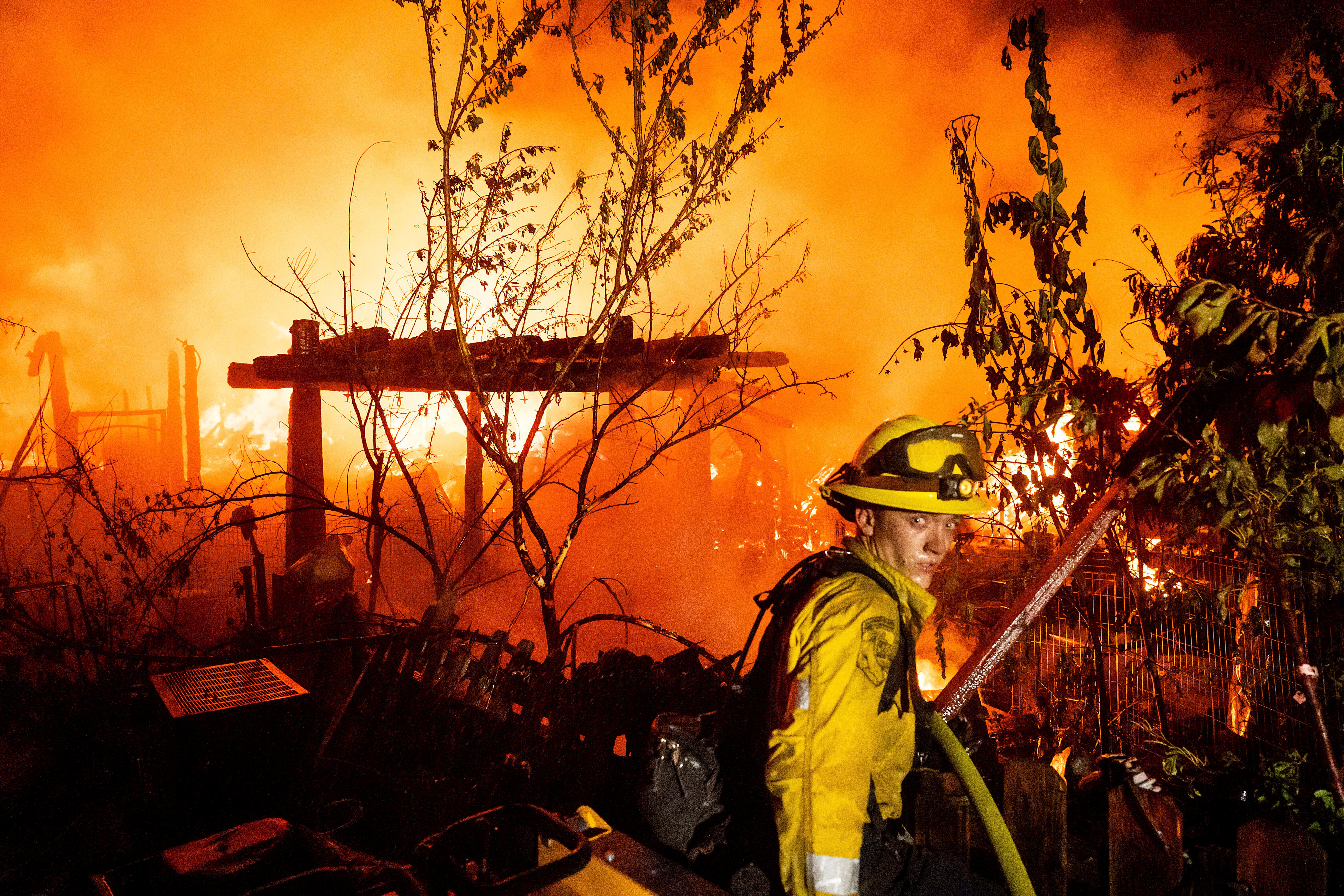 A firefighter battles the 6-5 Fire burning through the Chinese Camp community of Tuolumne County, Calif., on Tuesday, Sept. 2, 2025. (AP Photo/Noah Berger)