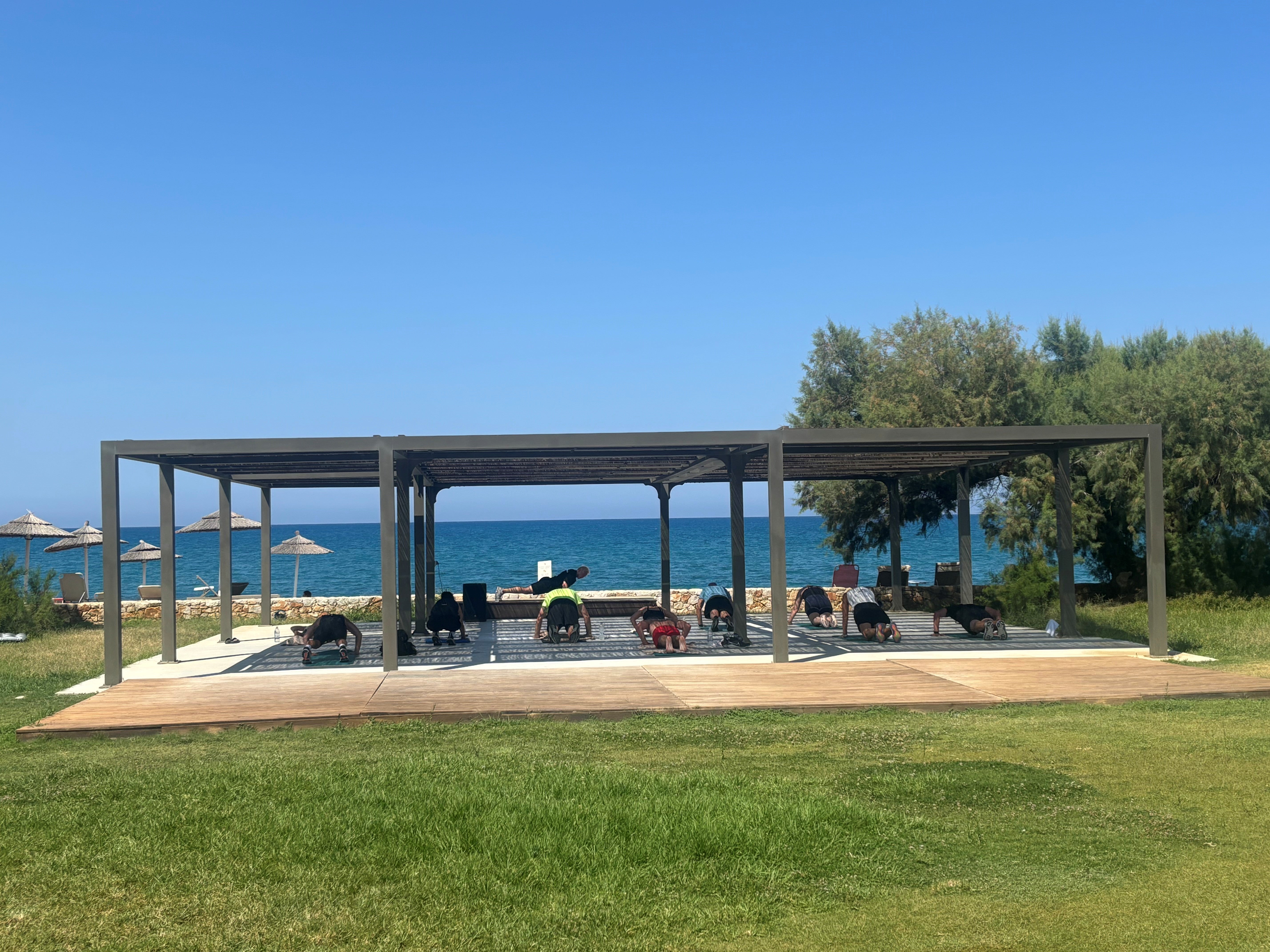 A group exercise class takes place by the beach