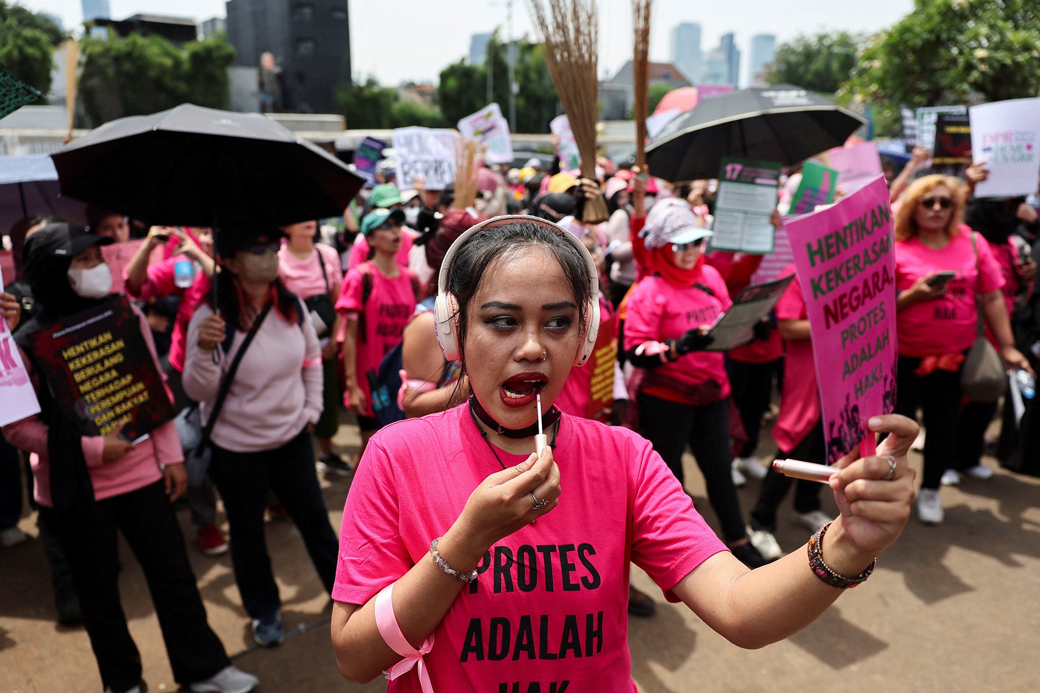 Protesters brandish brooms as a symbol of their call for reform outside Indonesia’s parliament building in Jakarta on 3 September 2025