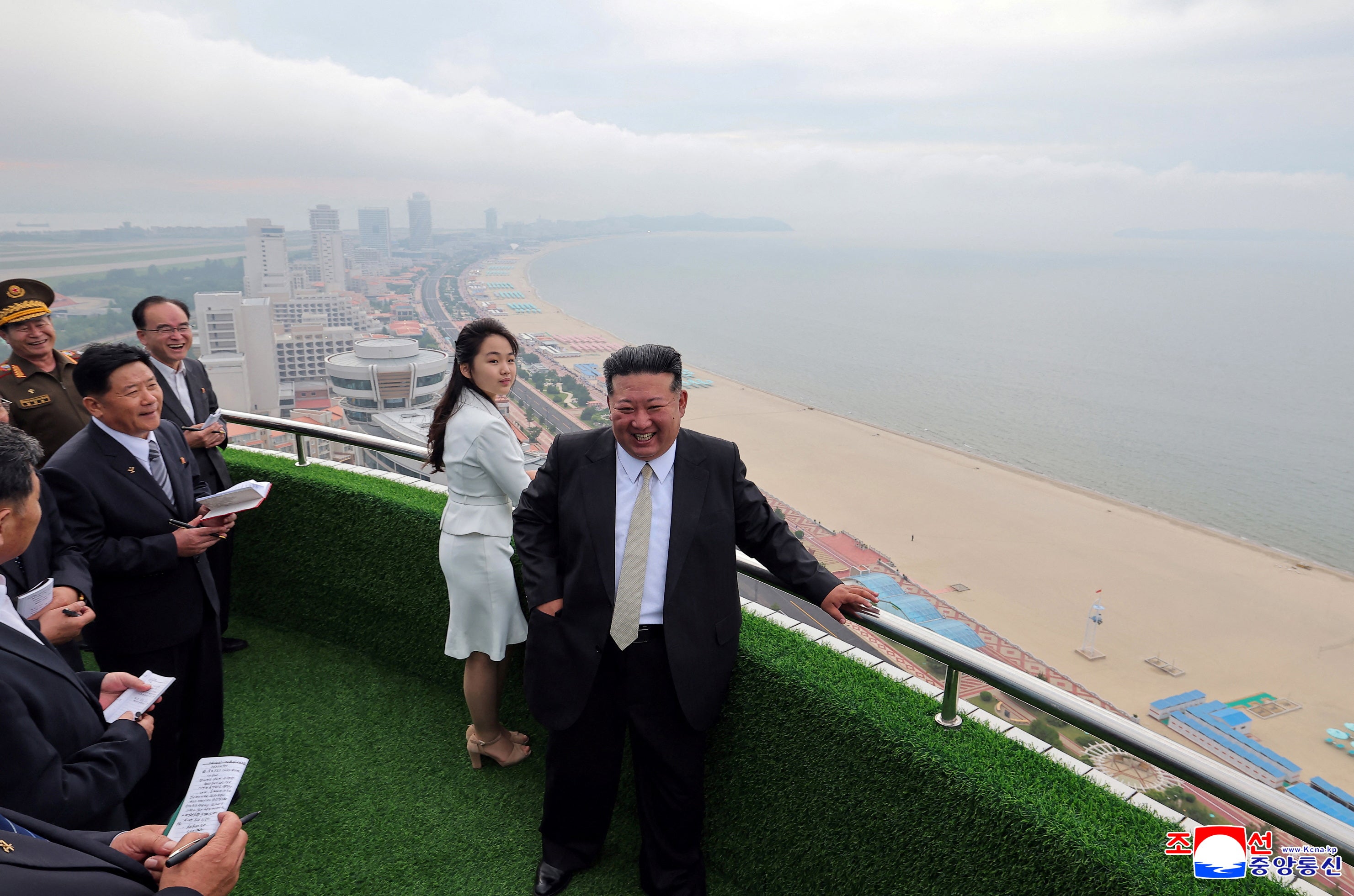 North Korean leader Kim Jong Un and his daughter Kim Ju Ae stand on a balcony facing the beach during a ceremony to celebrate the completion of the Wonsan Kalma Coastal Tourist Zone, in Wonsan, in North Korea, 24 June 2025
