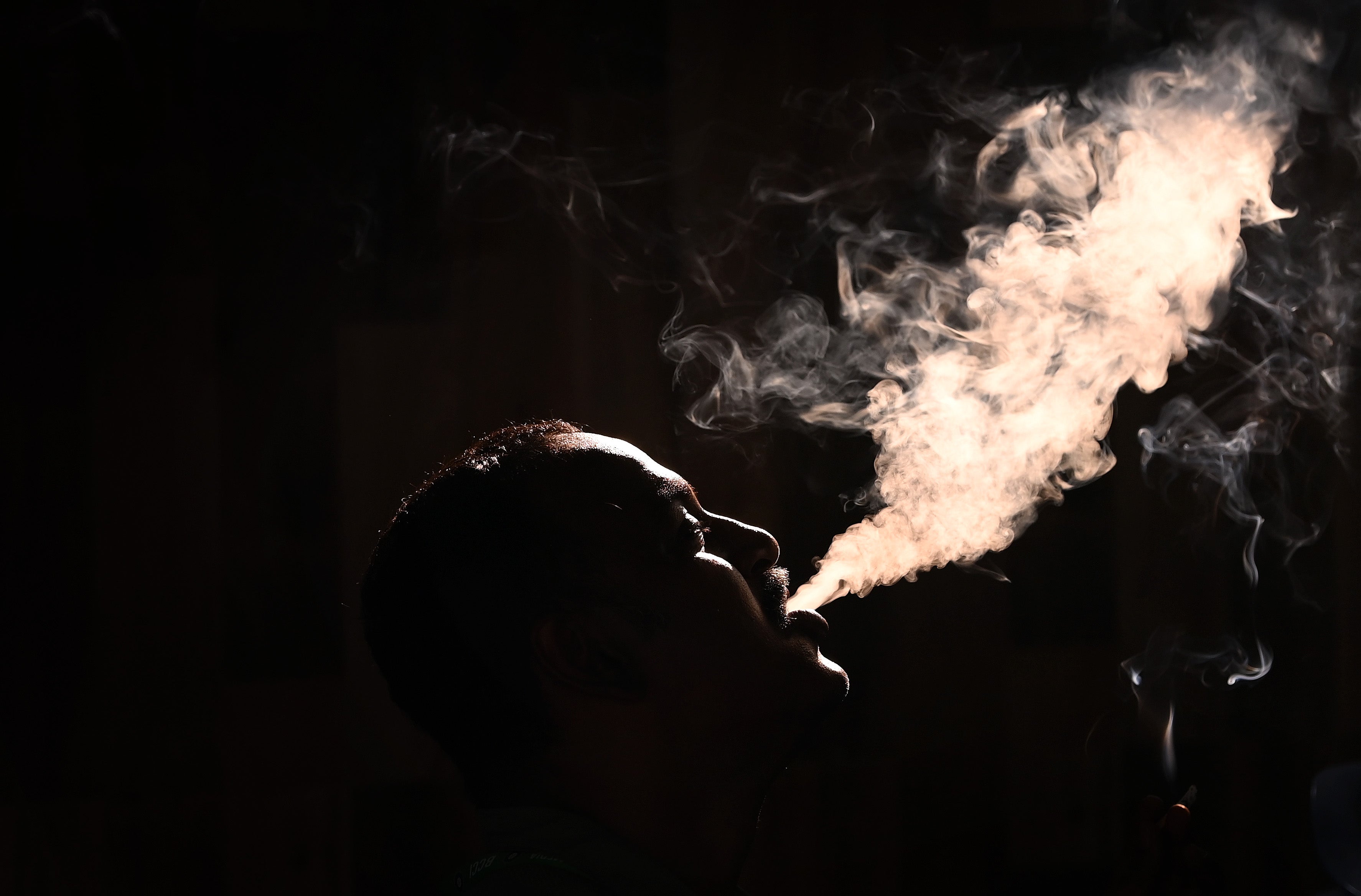 A man exhales smoke from a cigarette