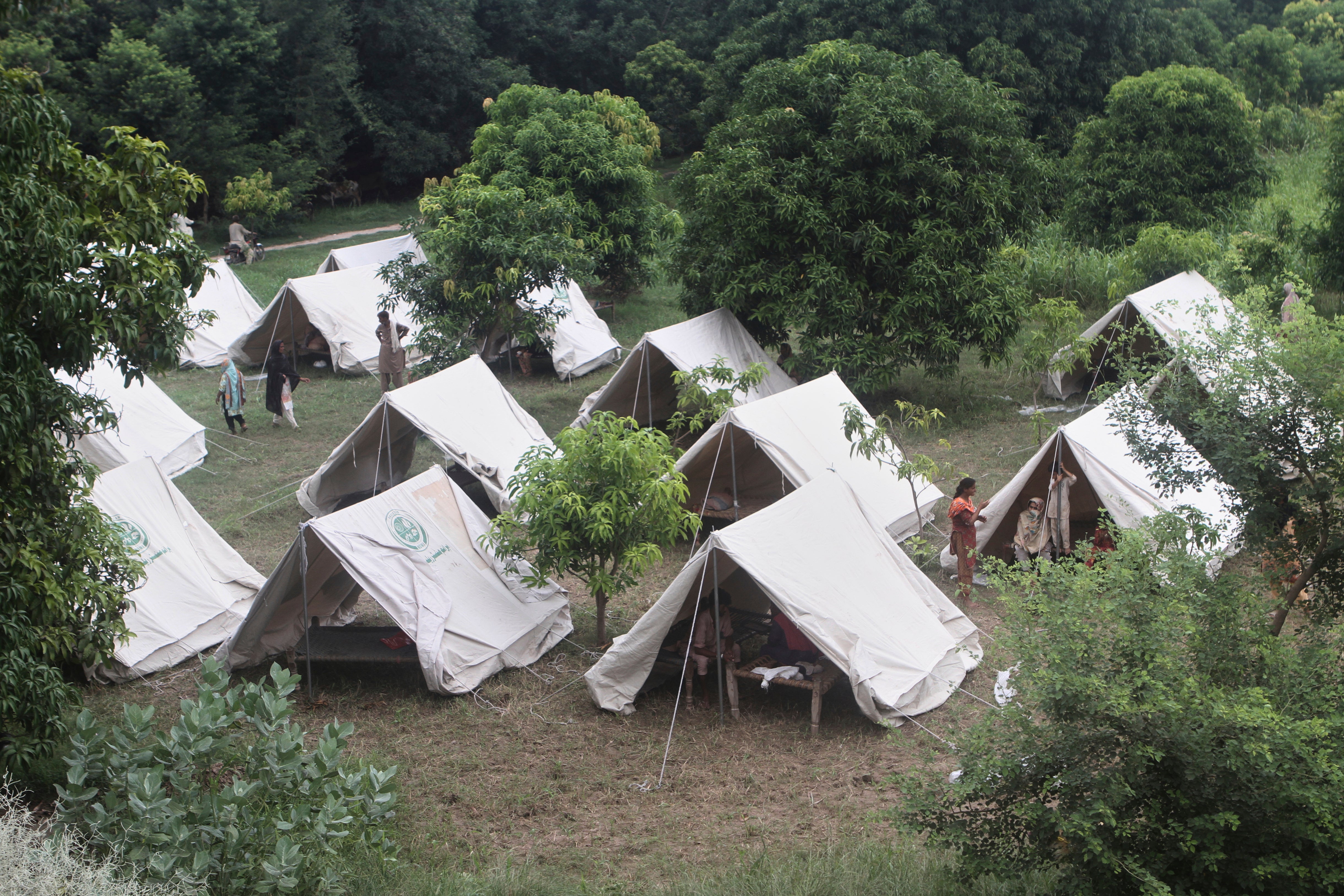 People, who fled from their homes due to flood take shelter at a relief camp on the outskirts of Multan, Pakistan