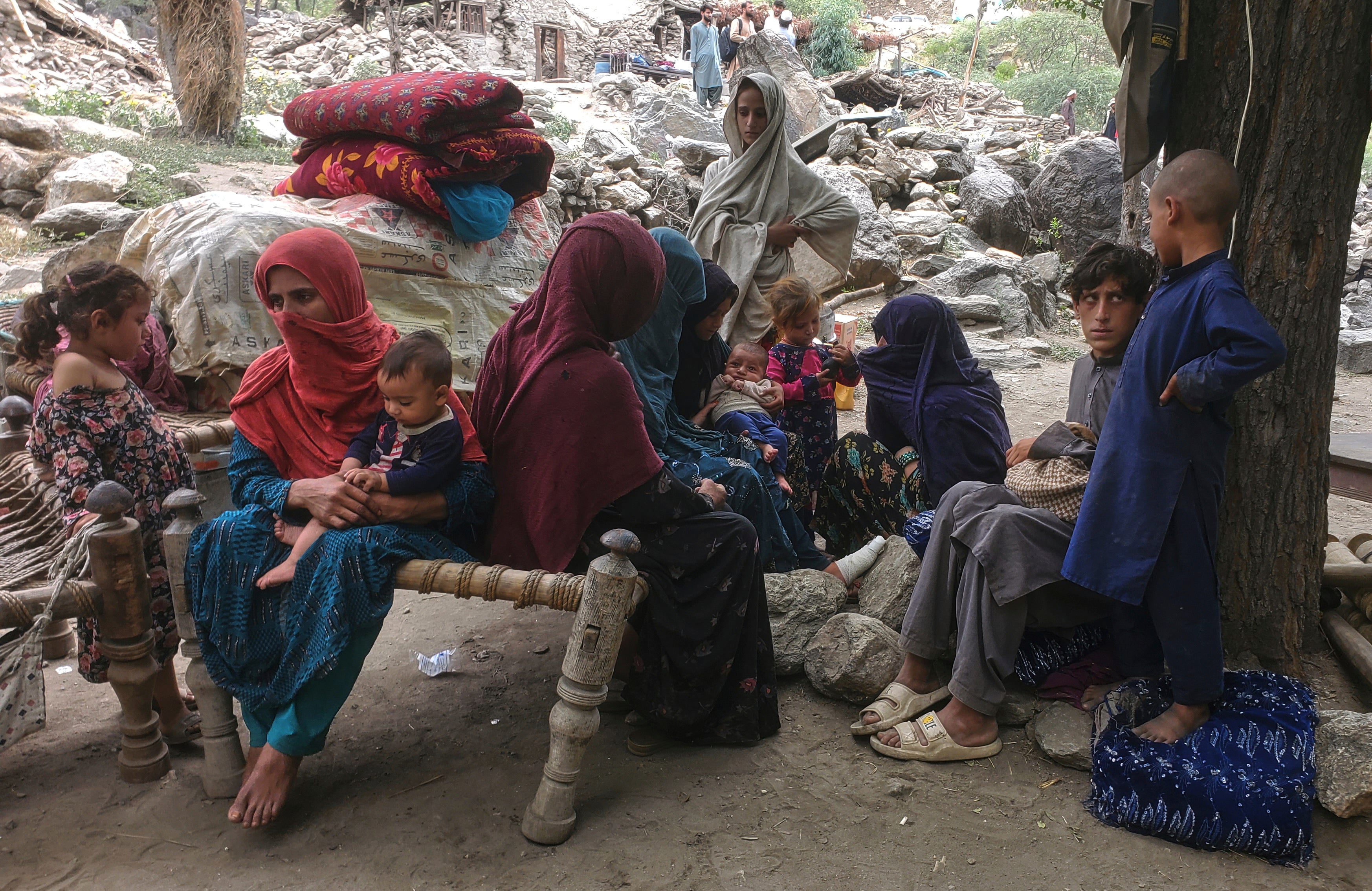 Displaced Afghan families gather under trees with their belongings after a powerful earthquake destroyed their homes in eastern Afghanistan