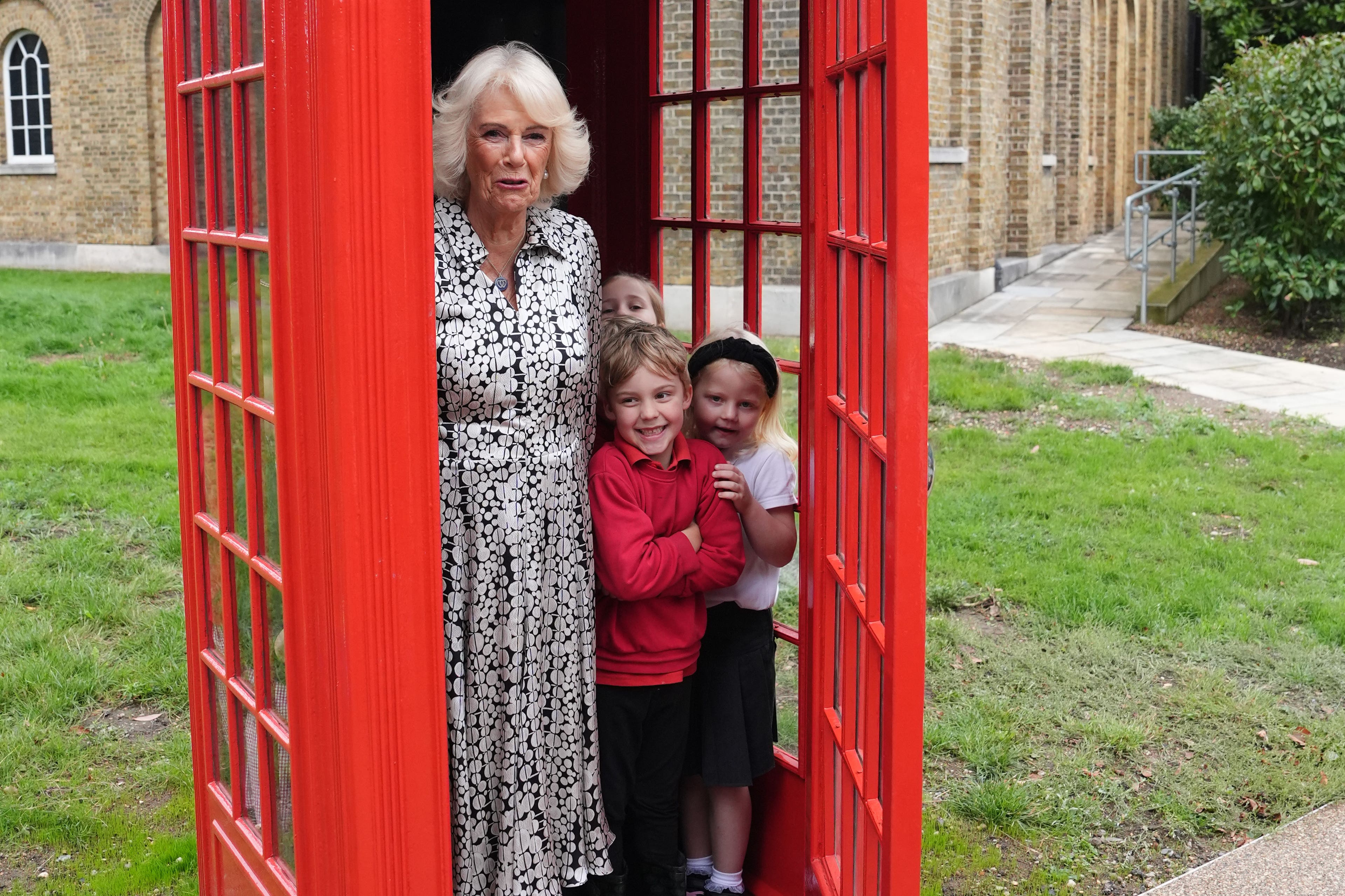 The Queen joins eight pupils from Dulwich Village Infants’ School in an original telephone box (Jonathan Brady/PA)