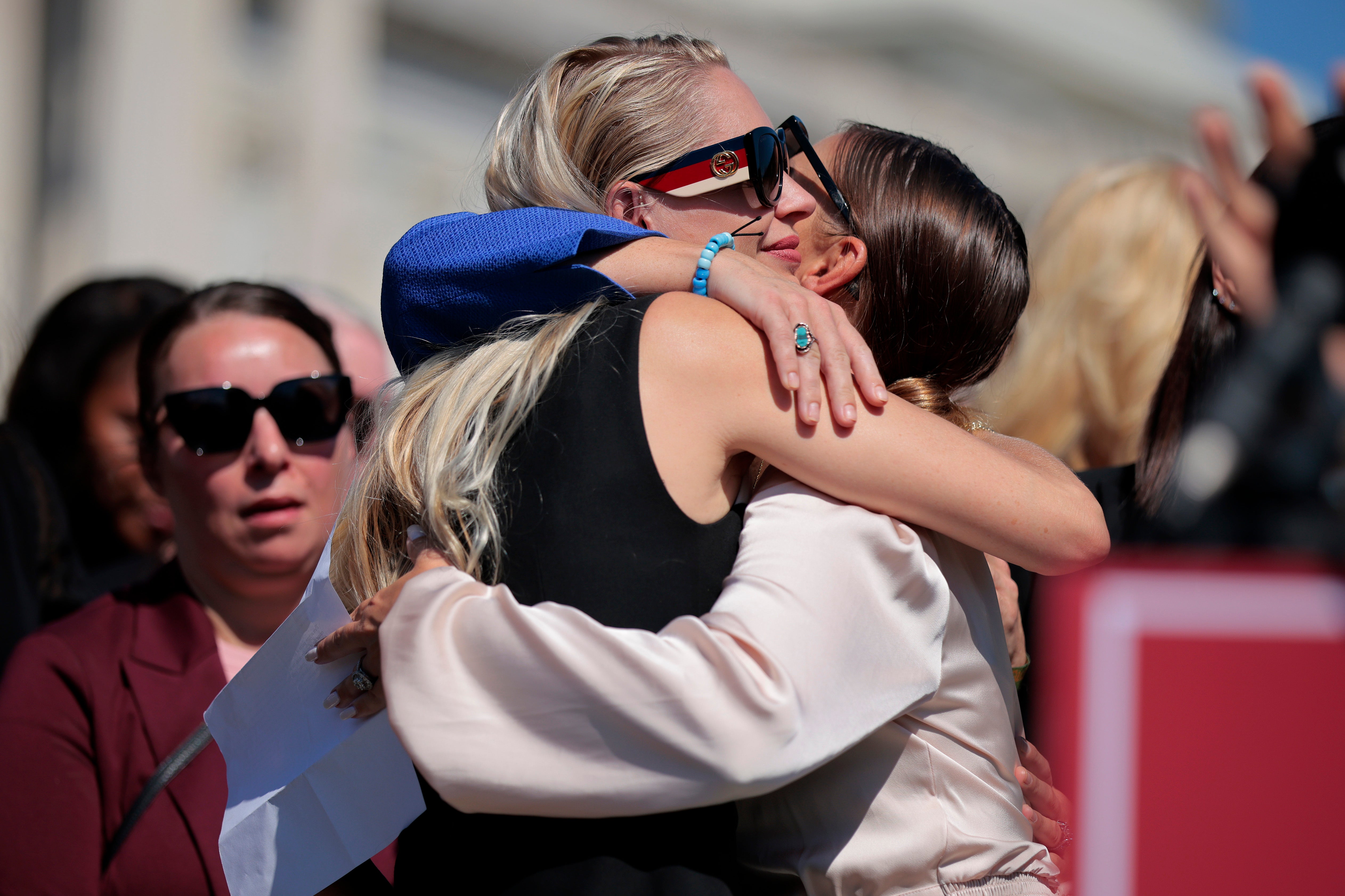 De Georgiou embraces abuse survivor Marina Lacerda (R)