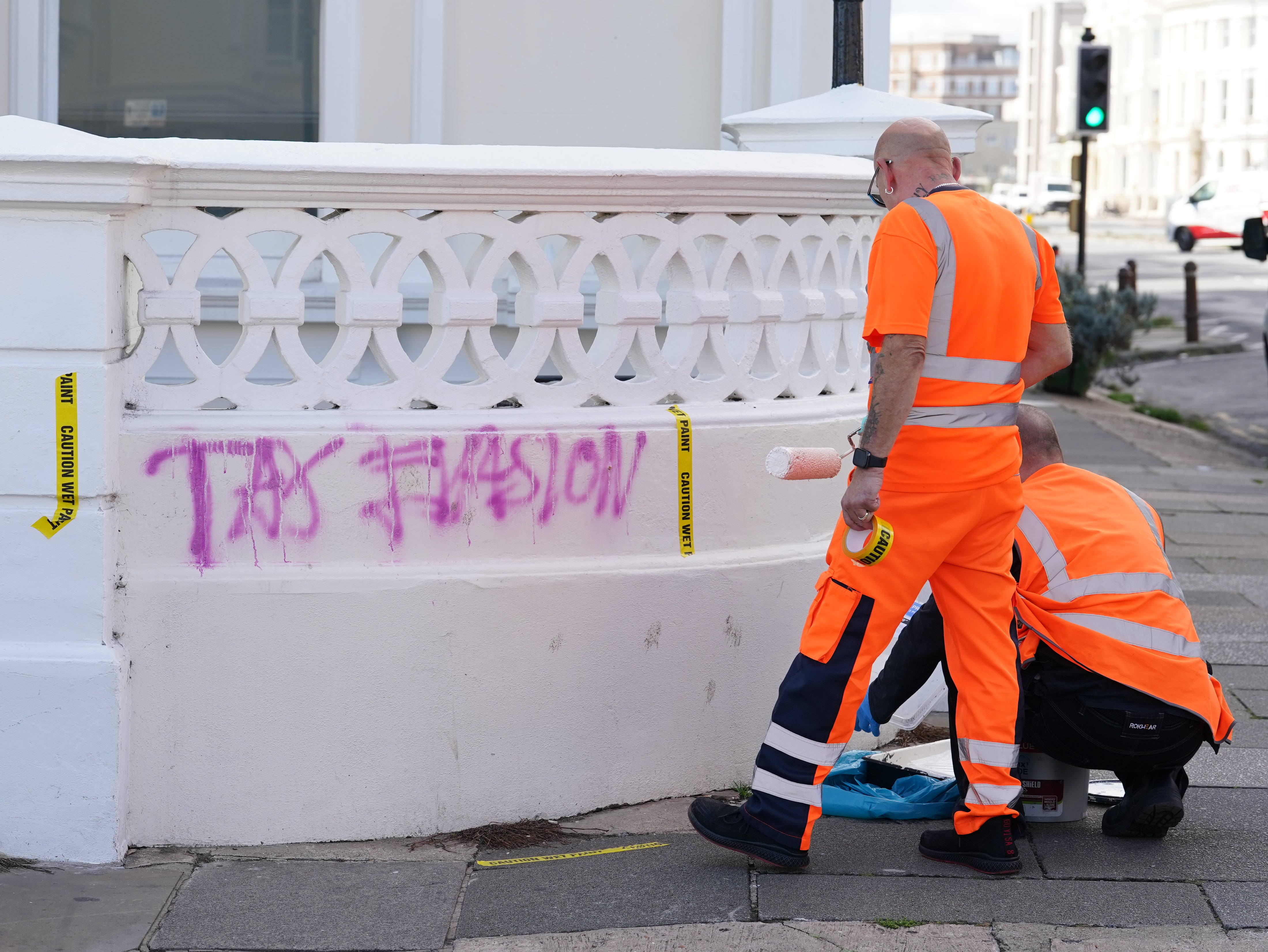 Workers prepare to clean graffiti off a wall at Rayner’s home in Hove