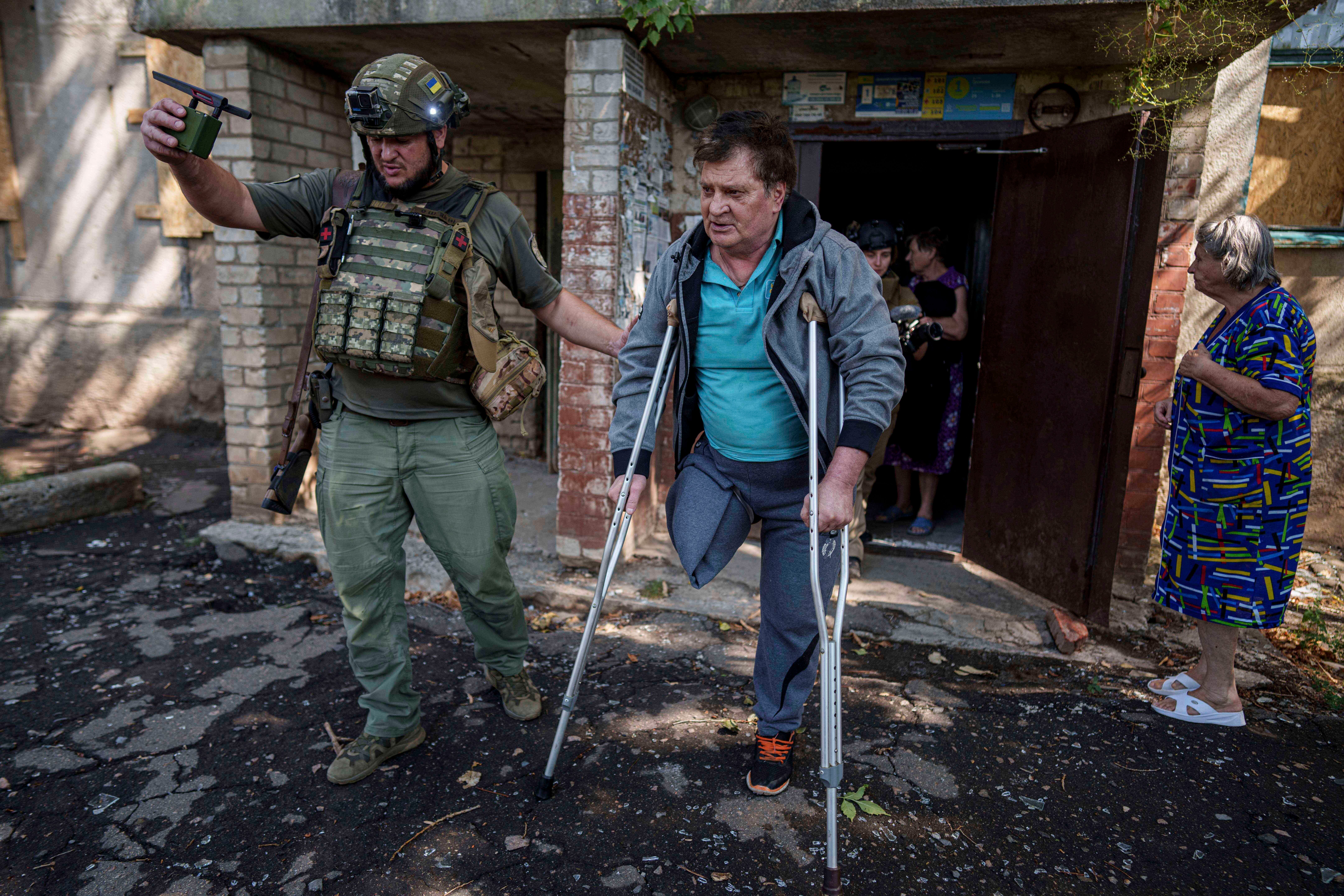 A police officer helps Mykhailo Maistruk, 67, during evacuation from Kostiantynivka
