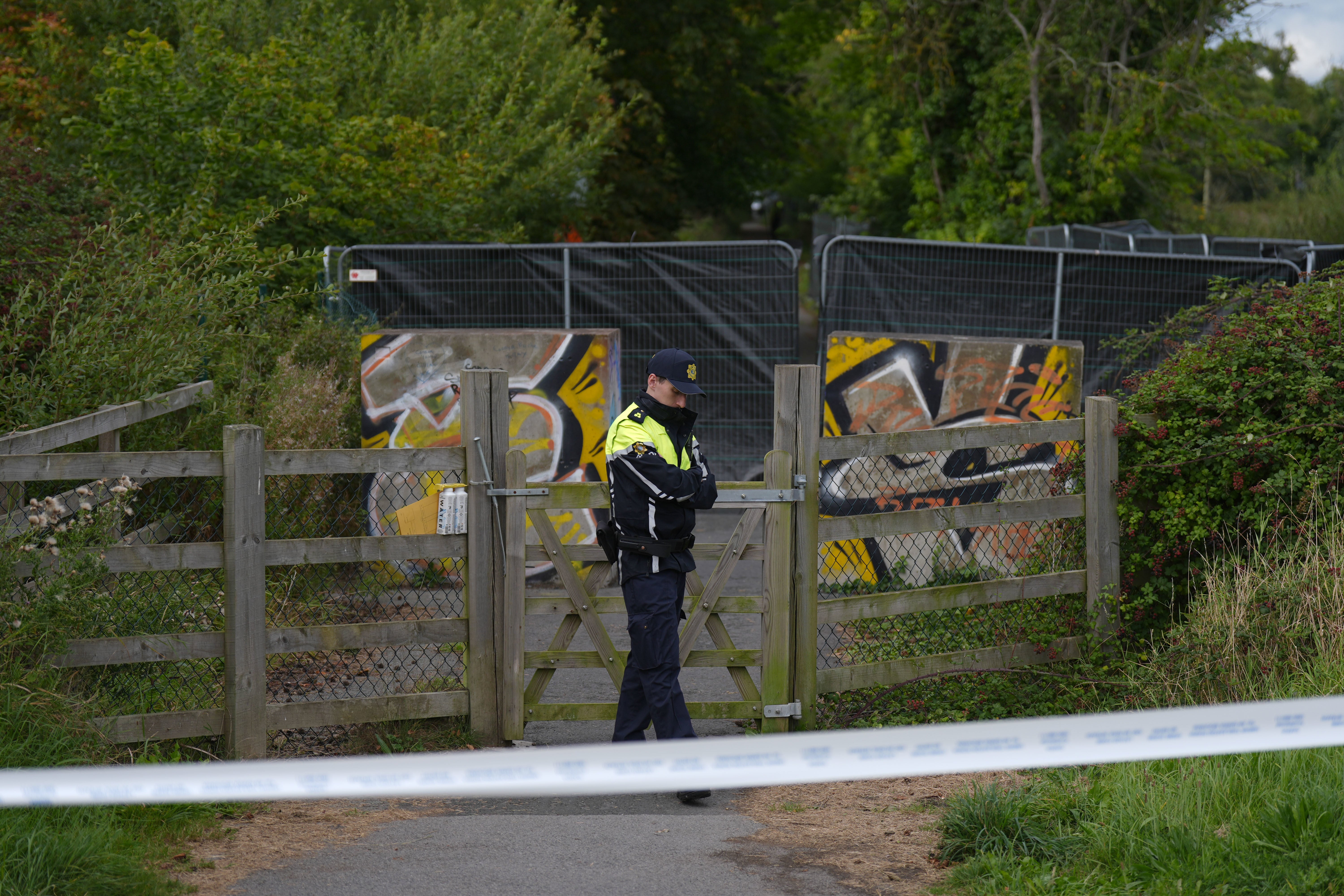 Gardai on an area of open ground in Donabate, Co Dublin during a search for a boy who has not been seen for several years (Niall Carson/PA)