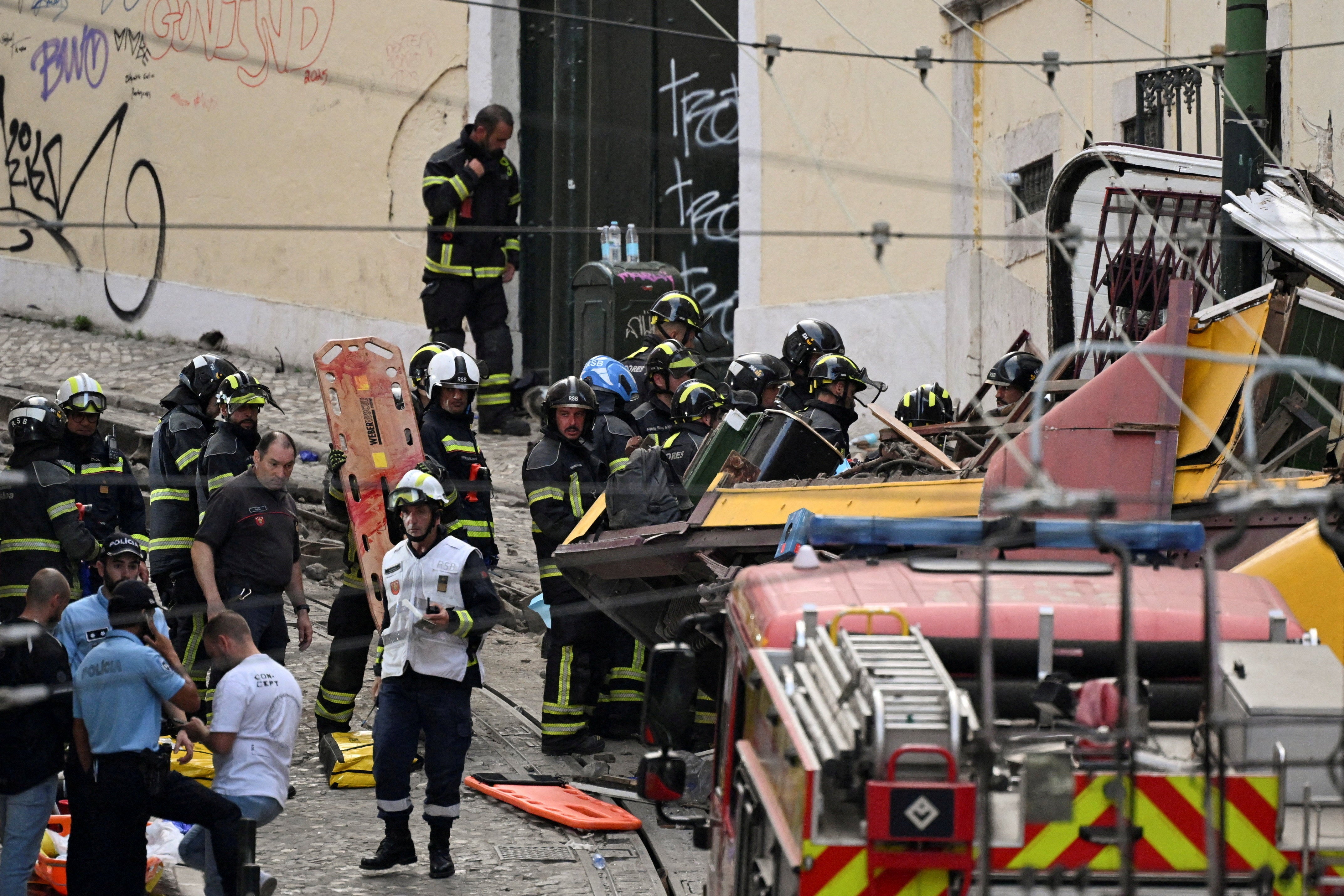 First responders work at the site of a funicular accident in Lisbon