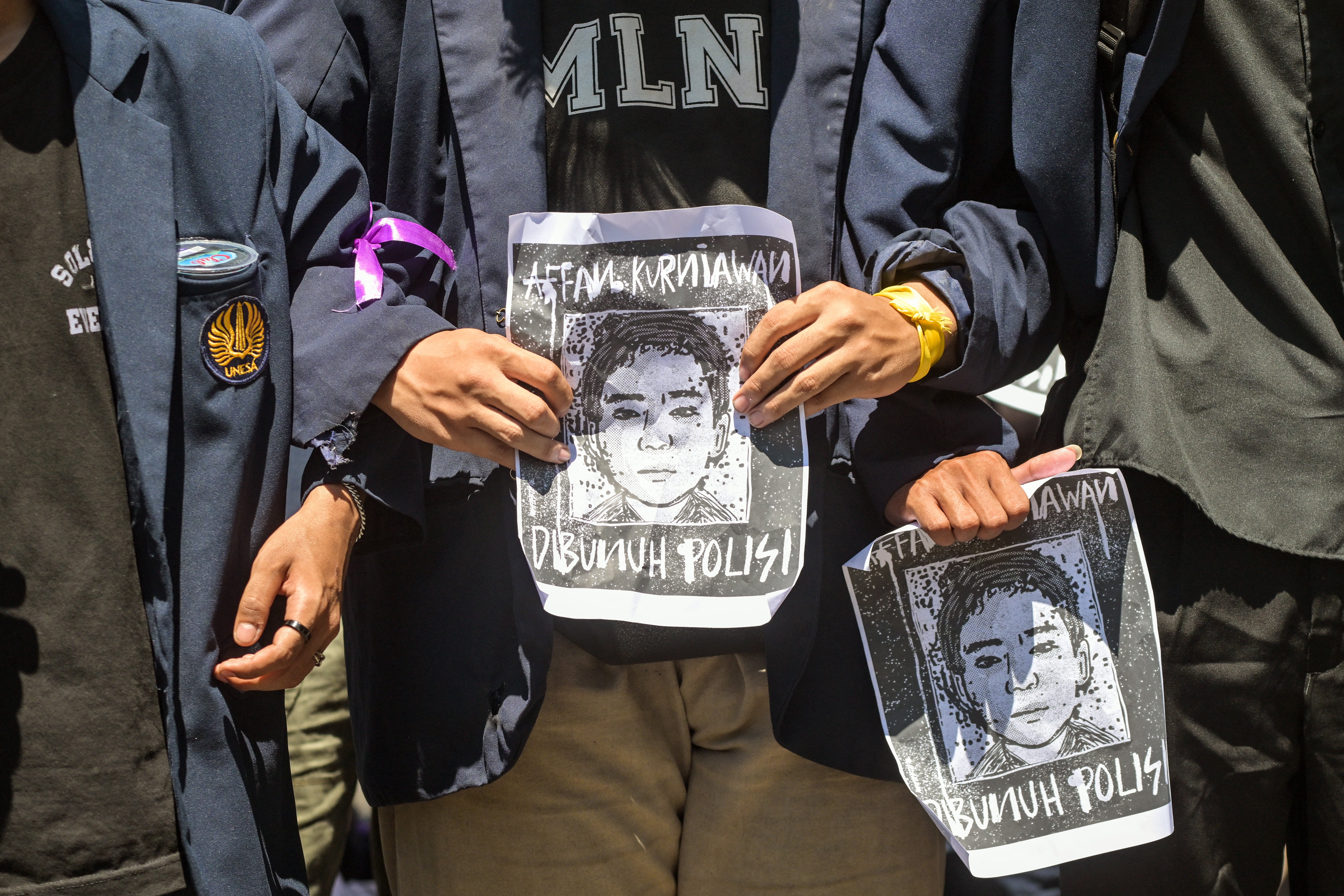 Protesters hold portraits of Affan Kurniawan in front of the Police headquarters in Surabaya