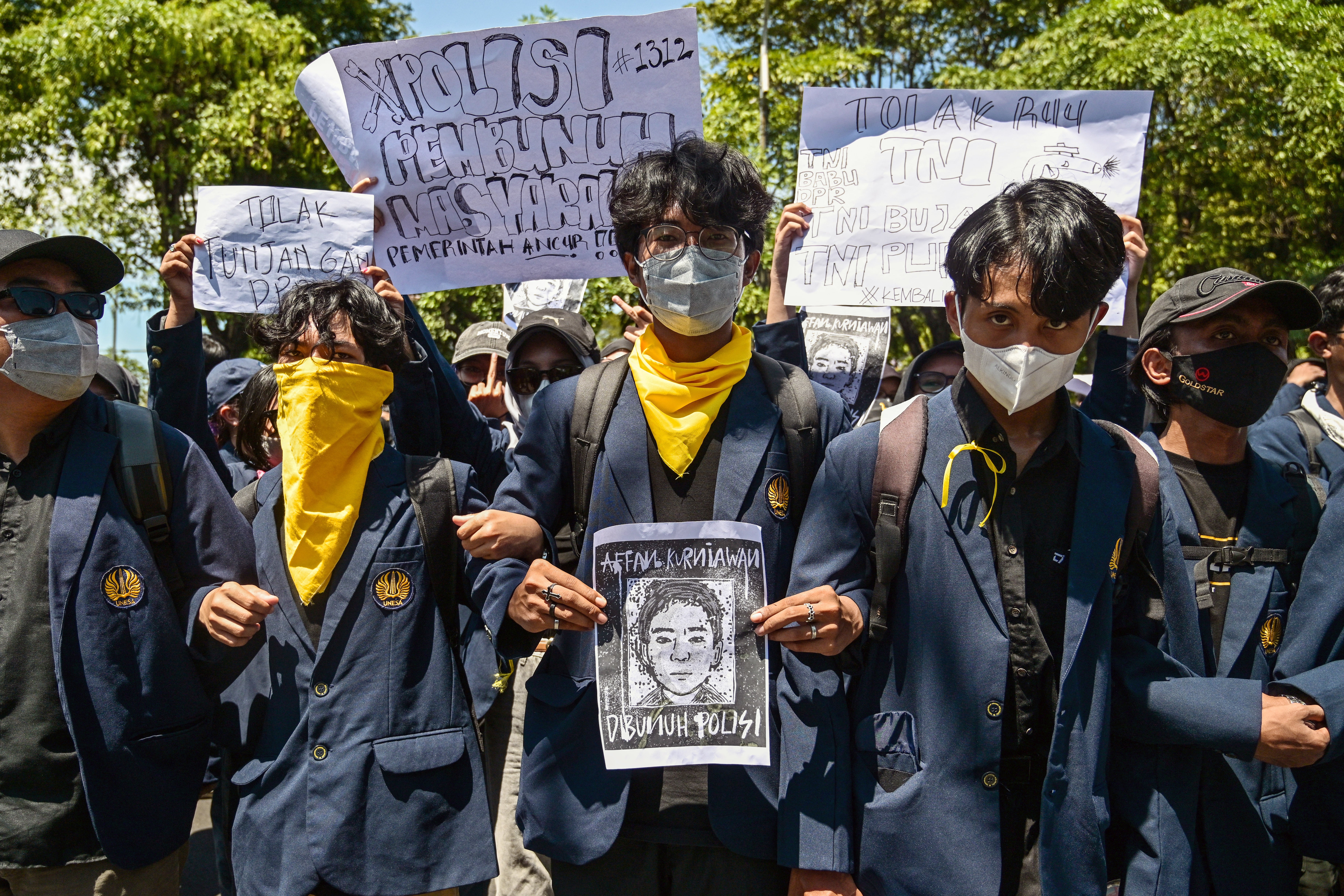 A demonstrator holds a portrait of Affan Kurniawan during a protest at the regional police headquarters in Surabaya