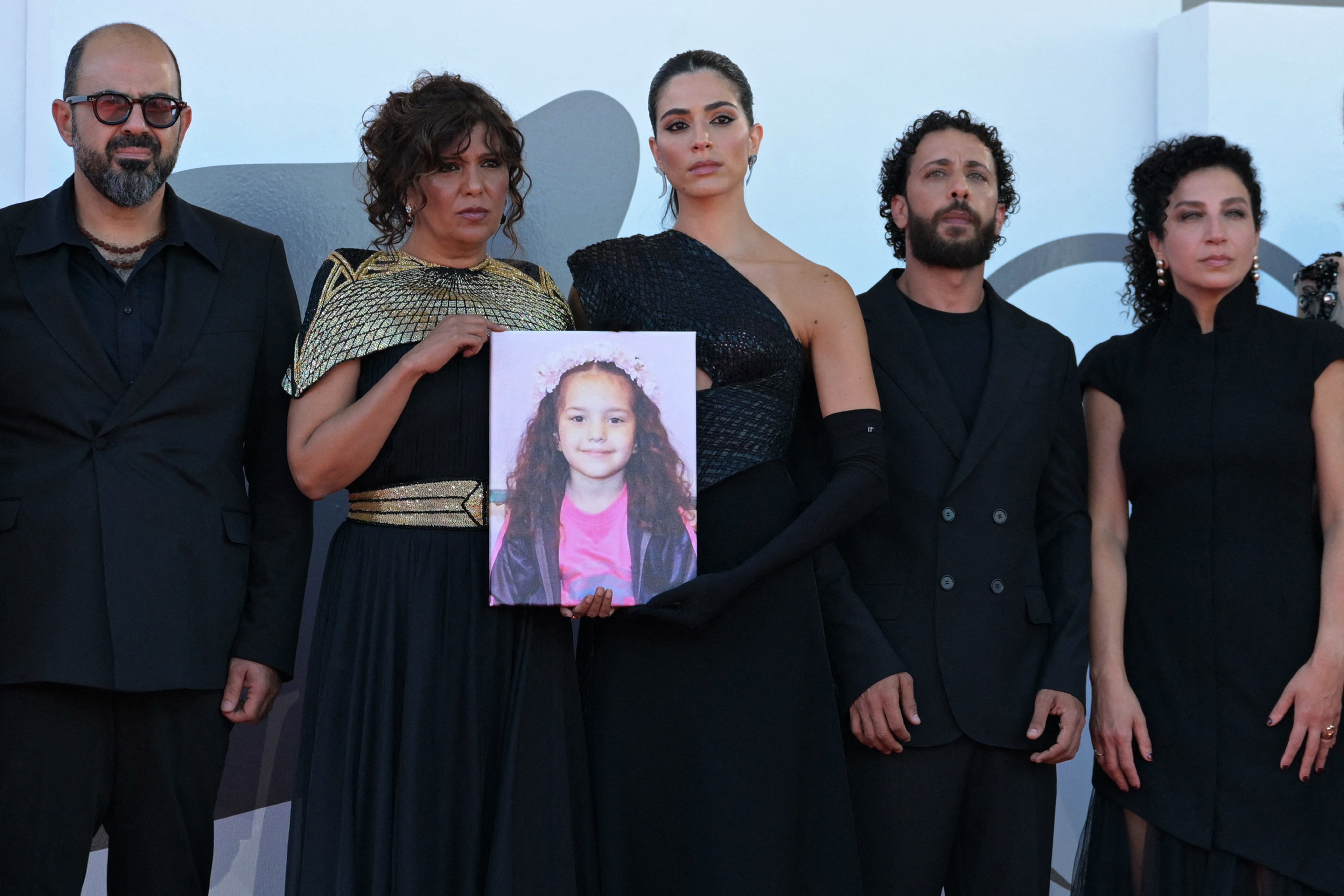 Israeli actor Amer Hlehel, director Kaouther Ben Hania, actress Saja Kilani, actor Motaz Malhees, and actress Clara Khoury pose with a portrait of Hind Rajab at the Venice film festival