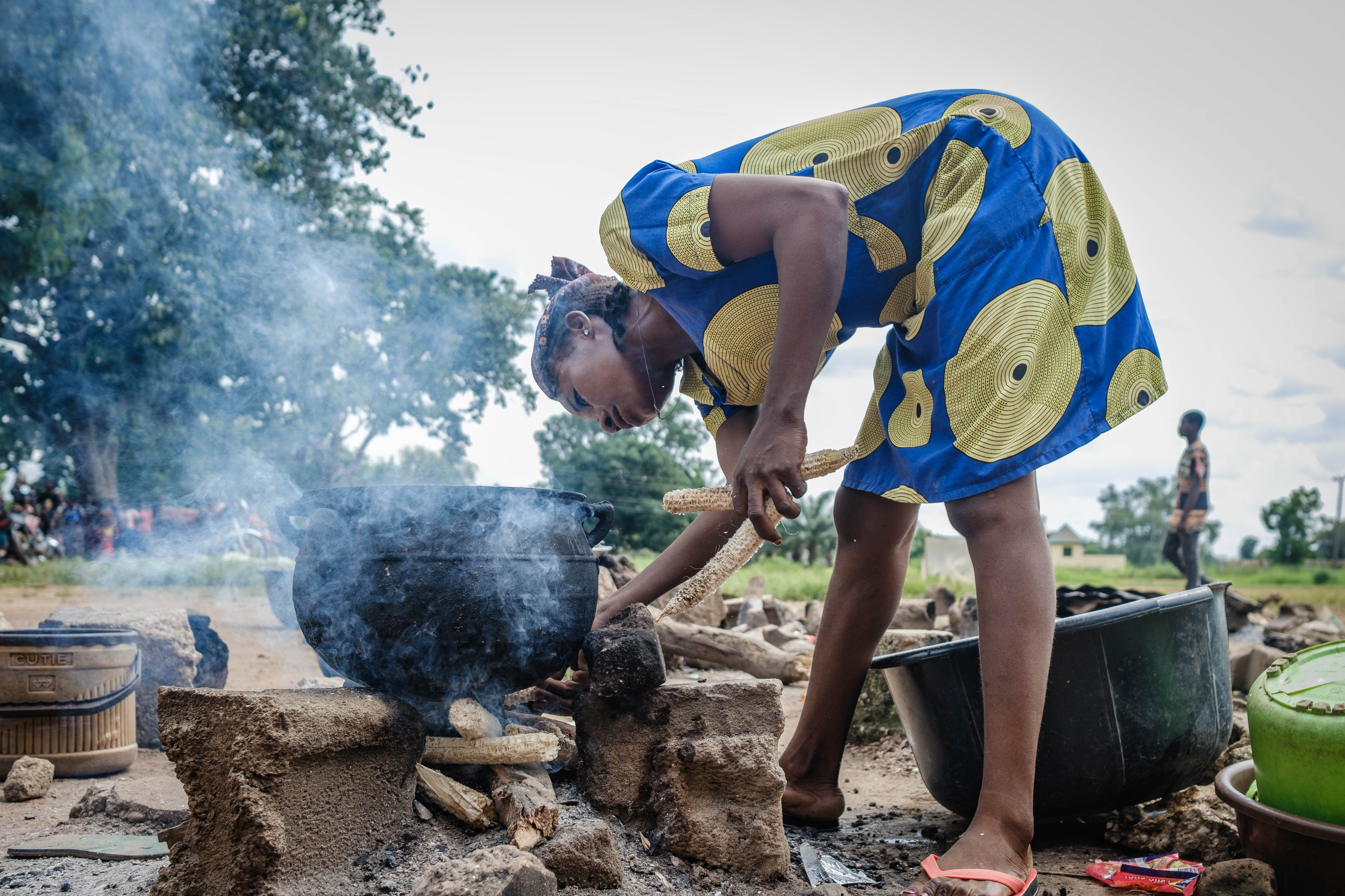 Jacob’s wife Agathe is seen cooking outside at Agagbe IDP camp. The family have been living in the camp since 2021