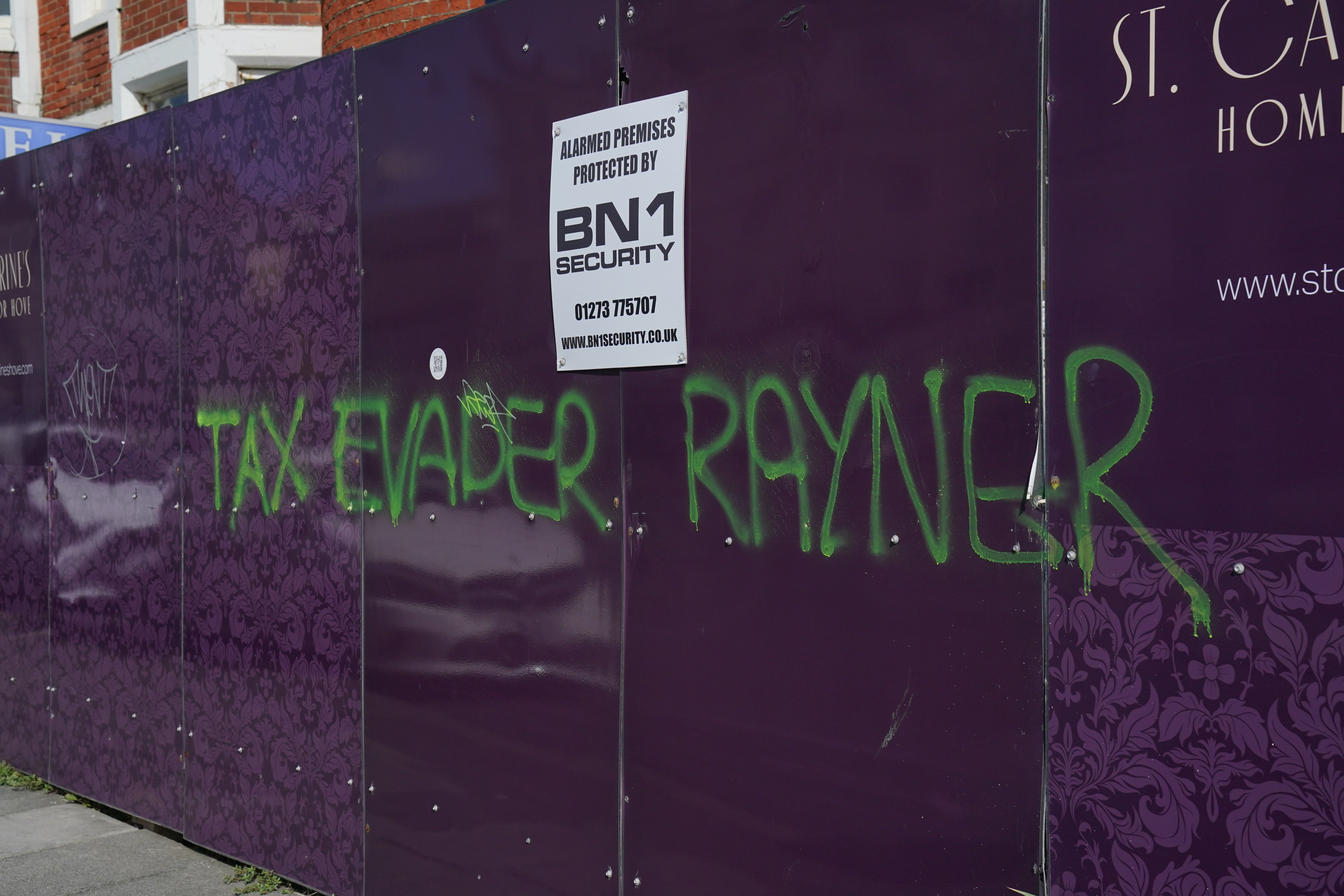 An additional message of “Tax evader Rayner” could also be seen graffitied on a construction clipboard nearby